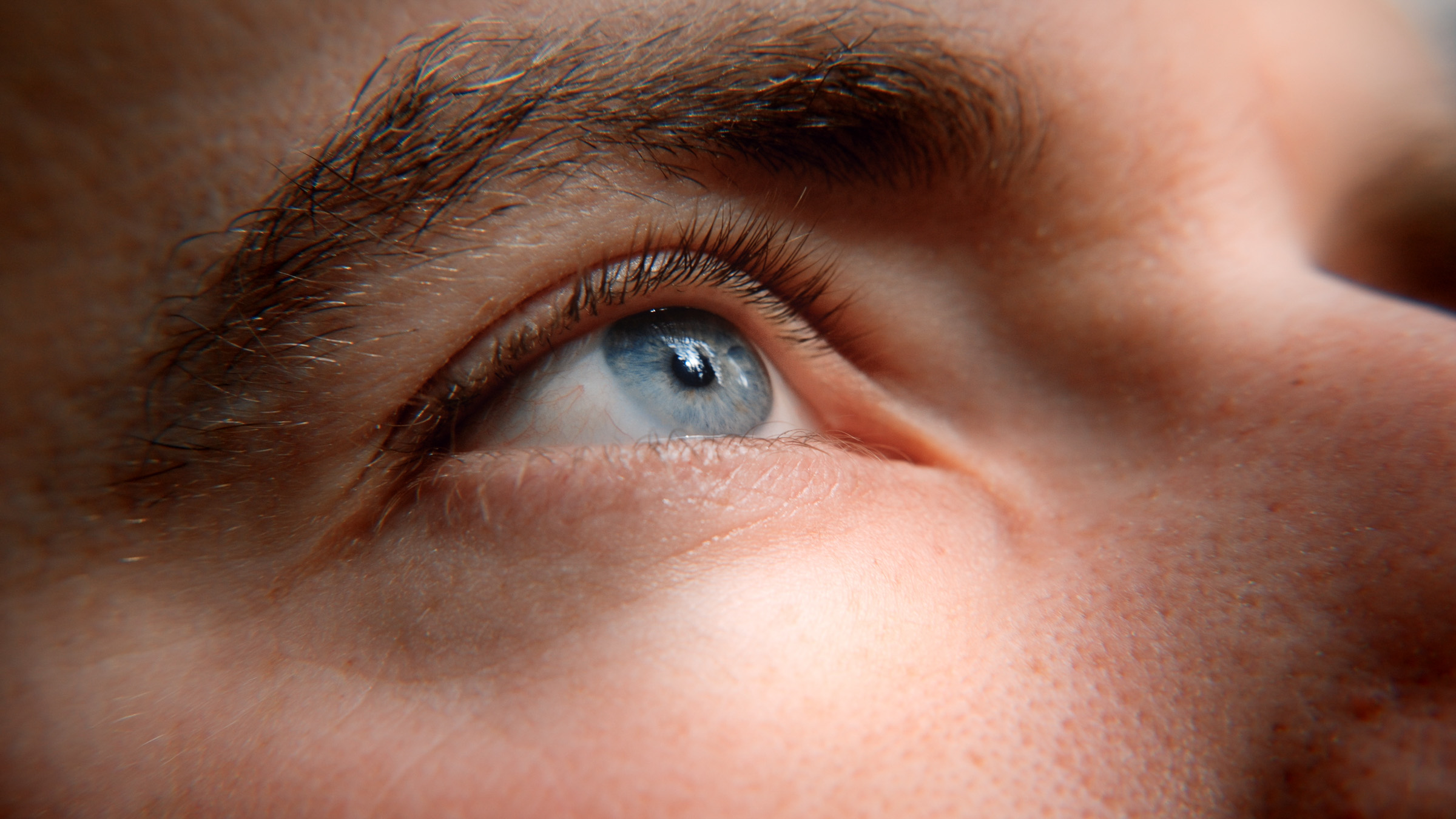 Close-up of a hiker's eye reflecting the bright sky