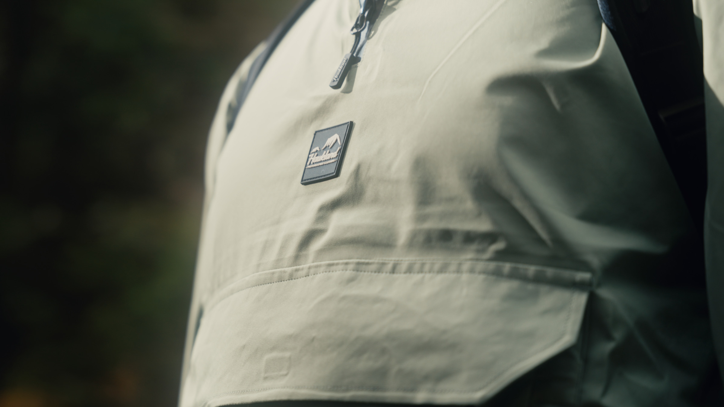 Close-up of the Haukland logo on a green outdoor jacket