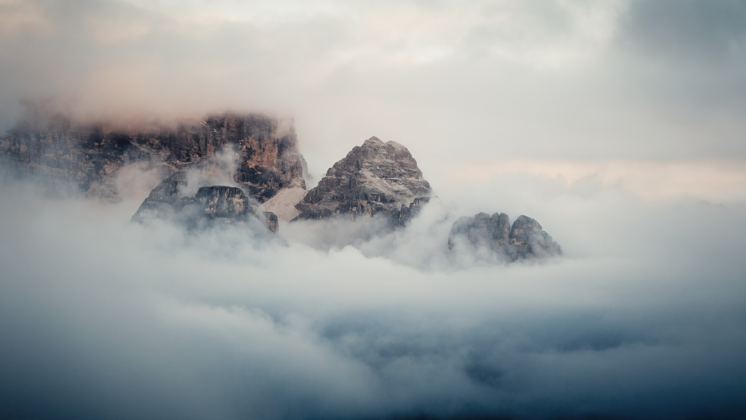 Jagged Dolomite peaks rising above a blanket of clouds