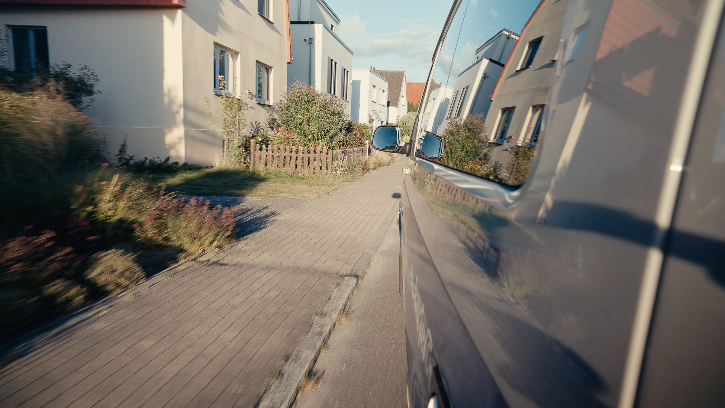 View from a moving camper through a quiet residential street