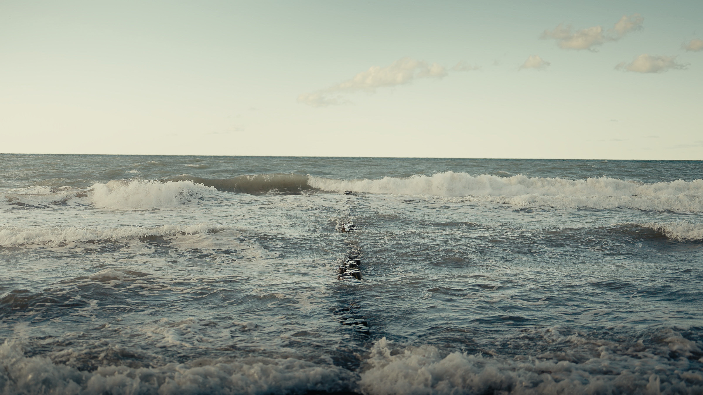 Foaming waves rolling toward the Baltic Sea shore