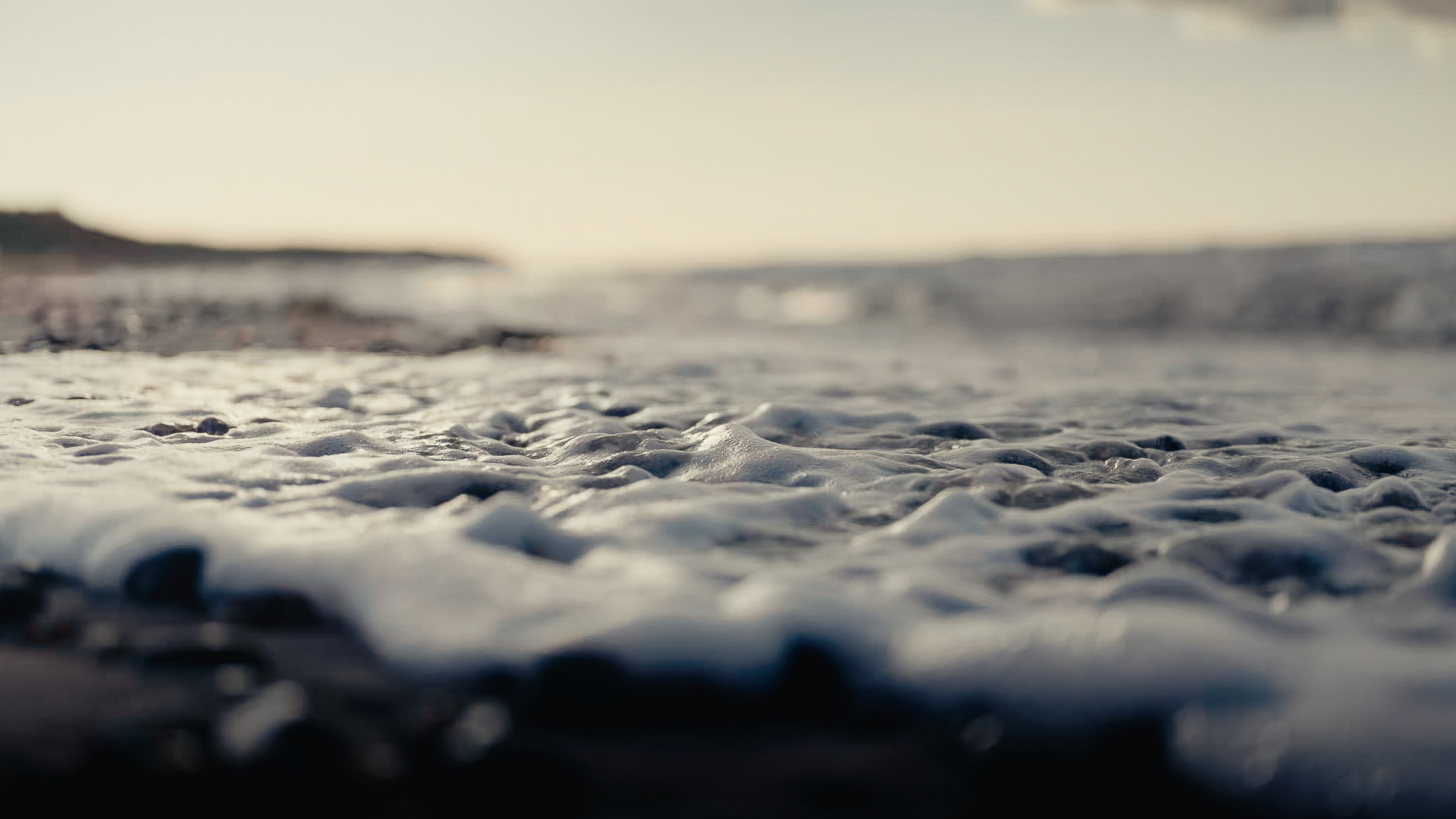 Close-up of sea foam spreading across the shoreline