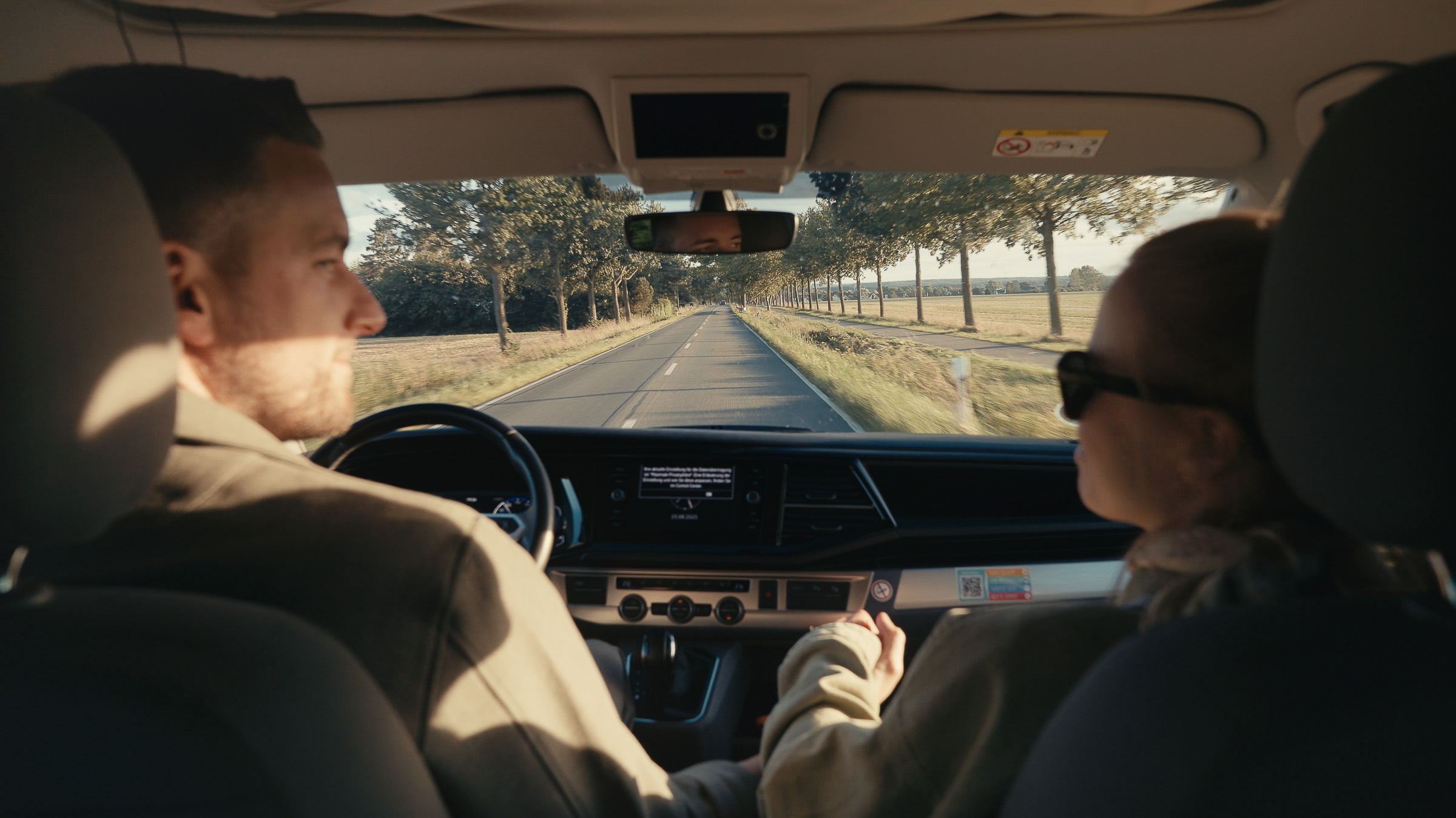 Couple traveling together in the front seats of a camper van