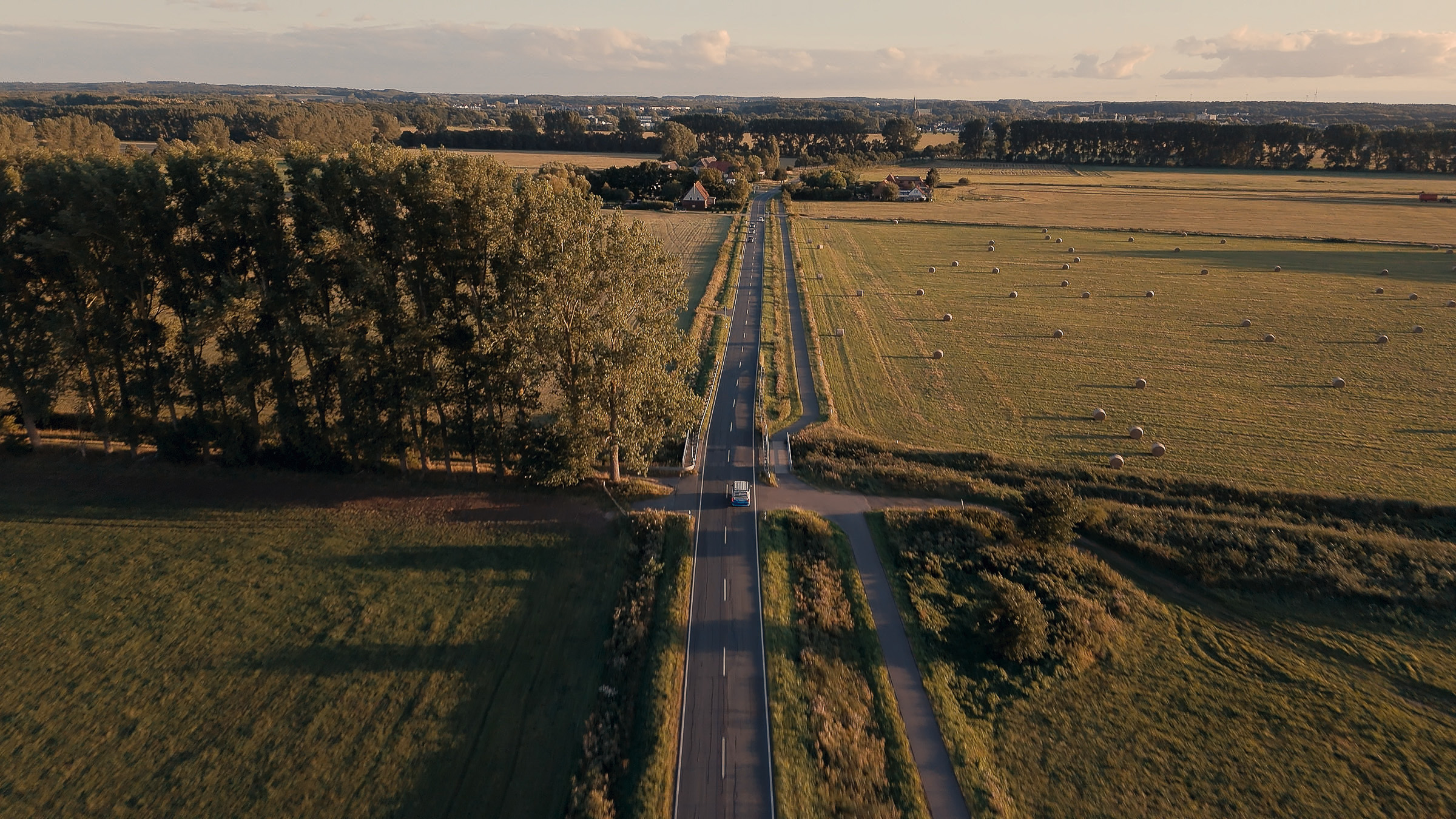 Aerial view of a straight country road through wide fields