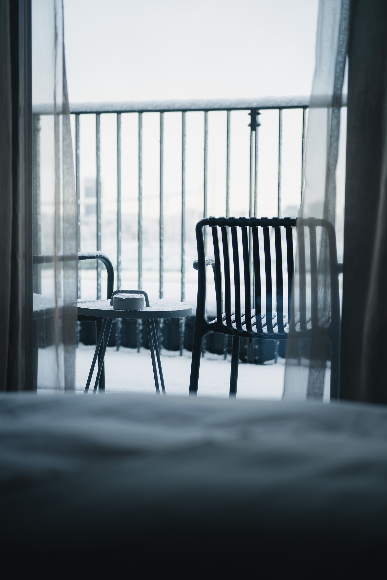 Balcony chairs seen through the window of a guest room at The George