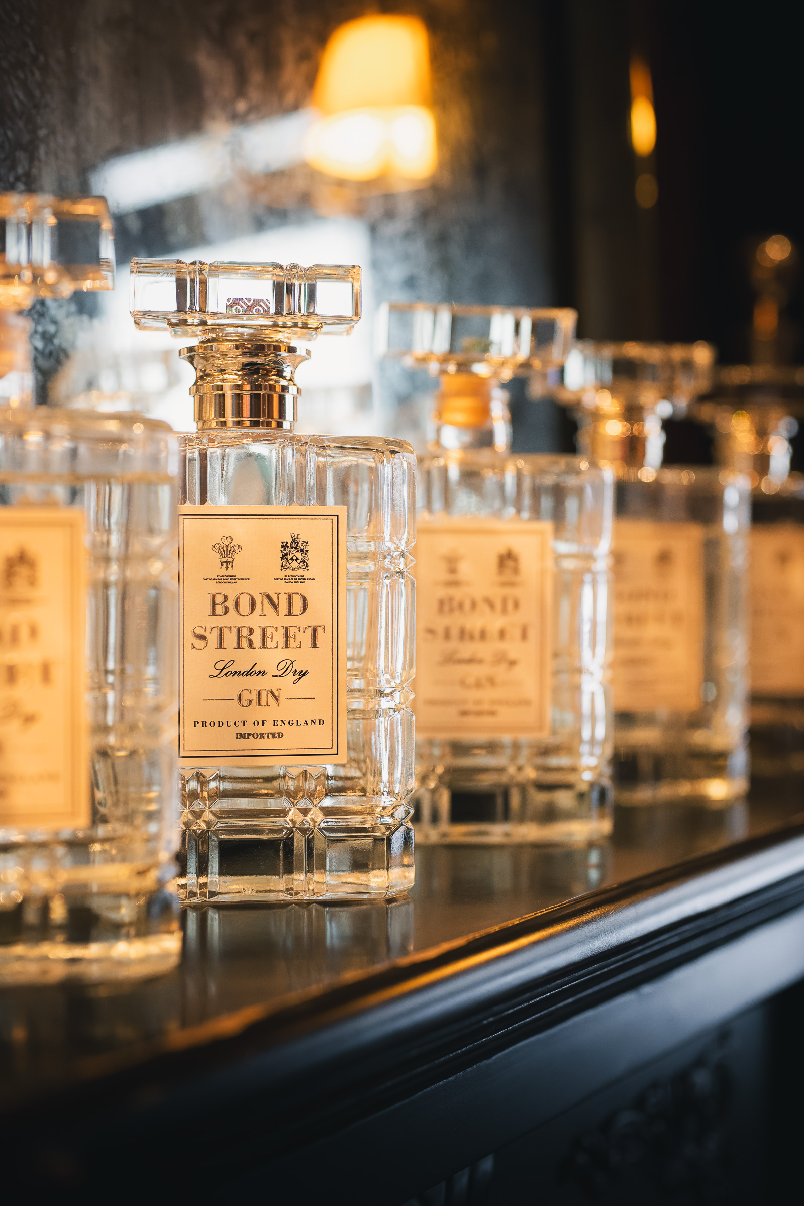 Row of Bond Street glass bottles on a mirrored shelf