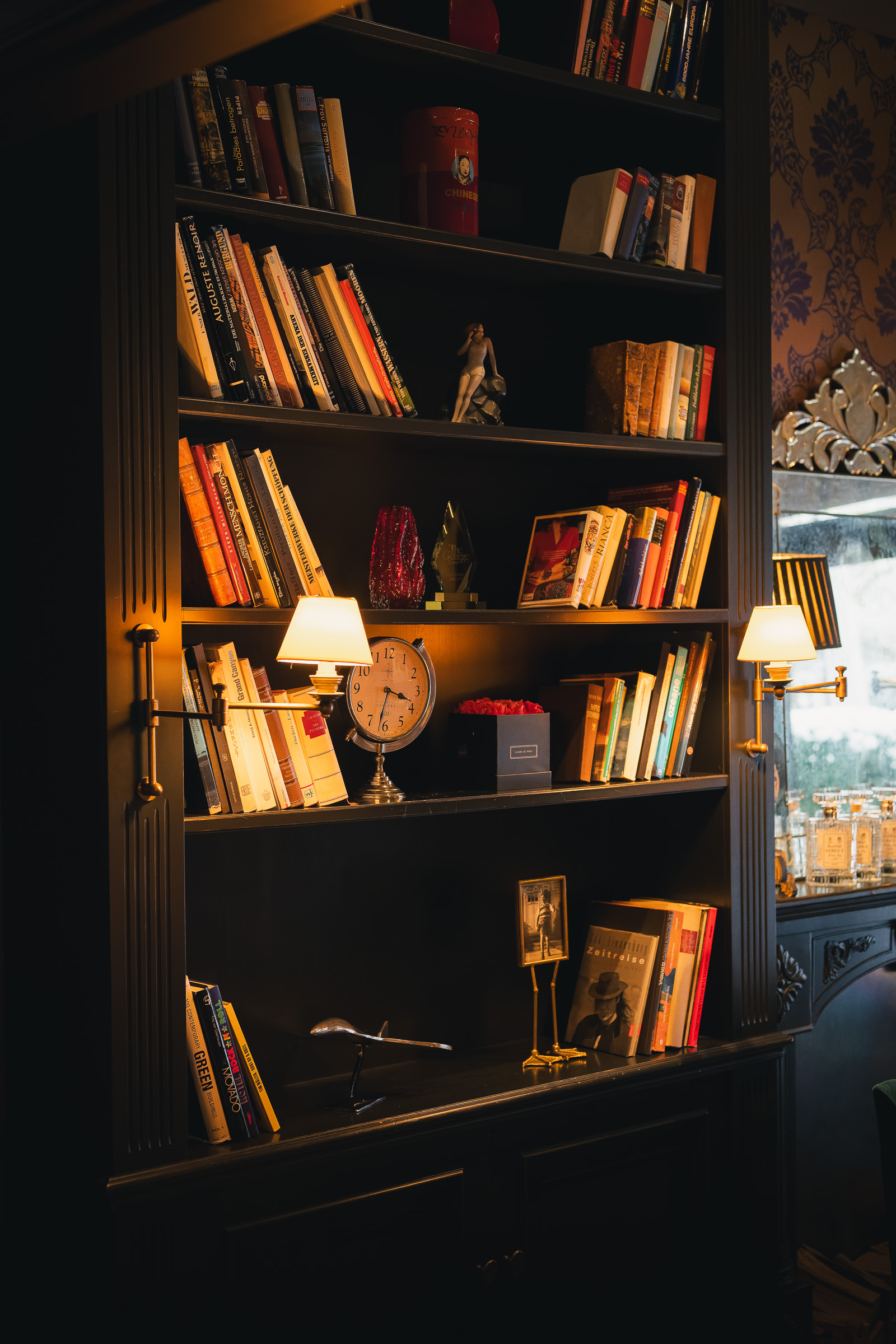 Tall bookshelf filled with books and decorative objects in the hotel lounge
