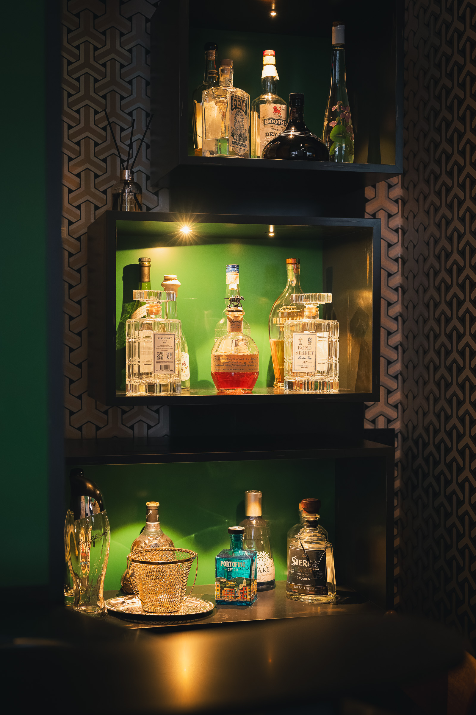 Illuminated display cabinet filled with colorful spirits bottles