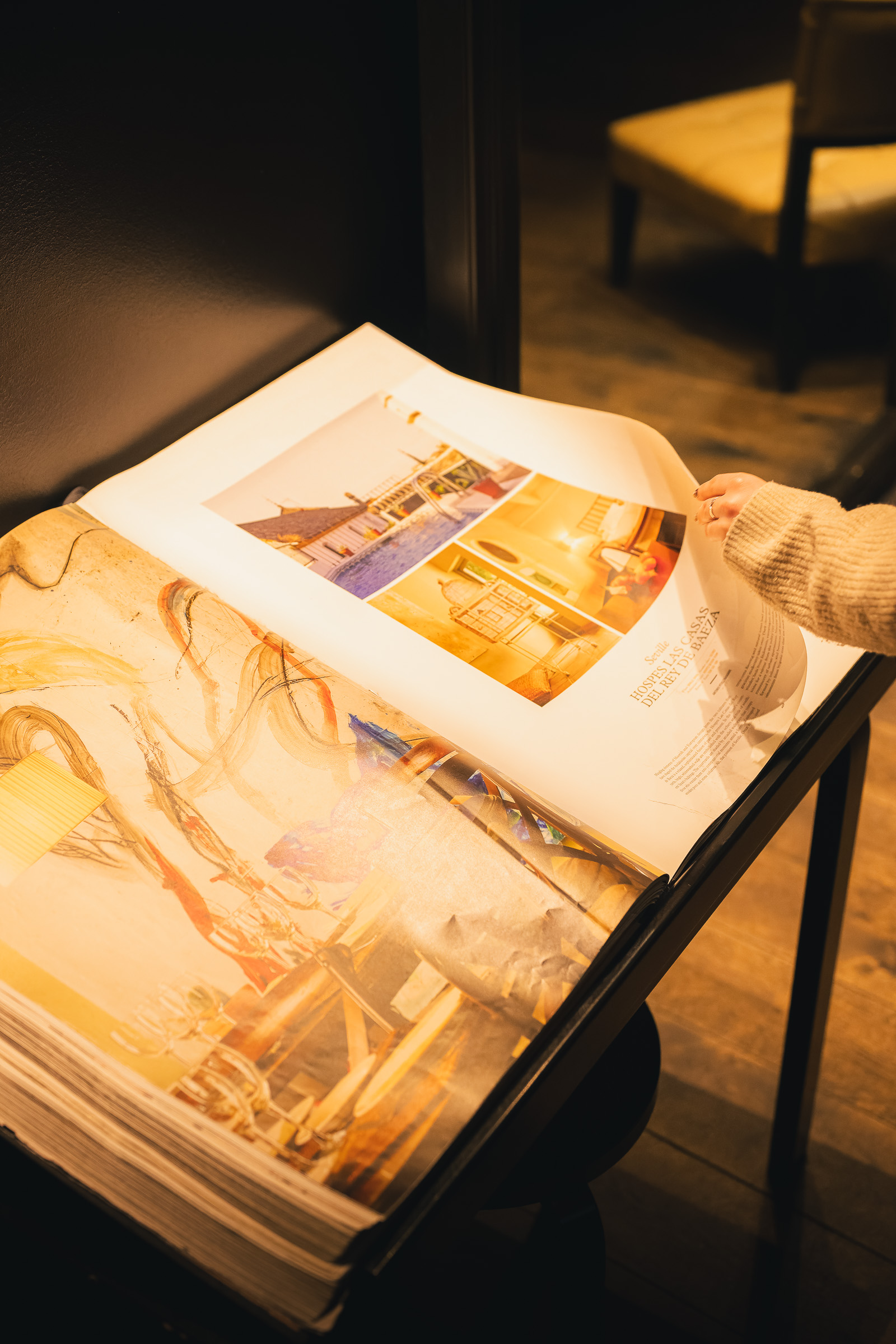 Open interior design magazine illuminated by a warm table lamp