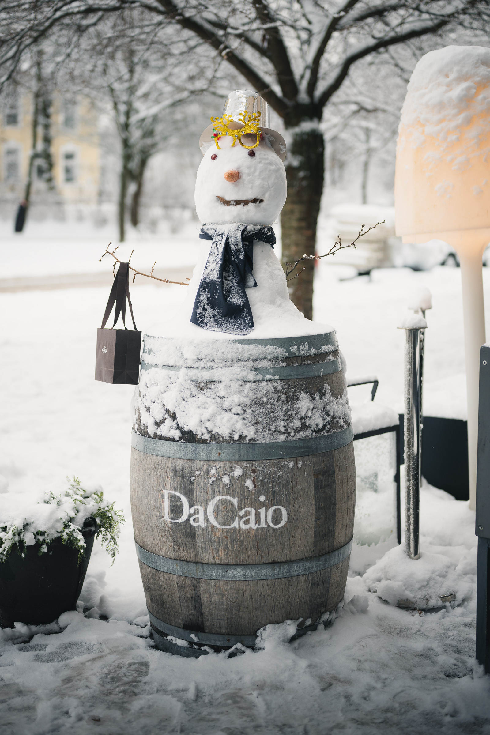 Snowman perched on a DaCaio barrel outside the hotel in winter