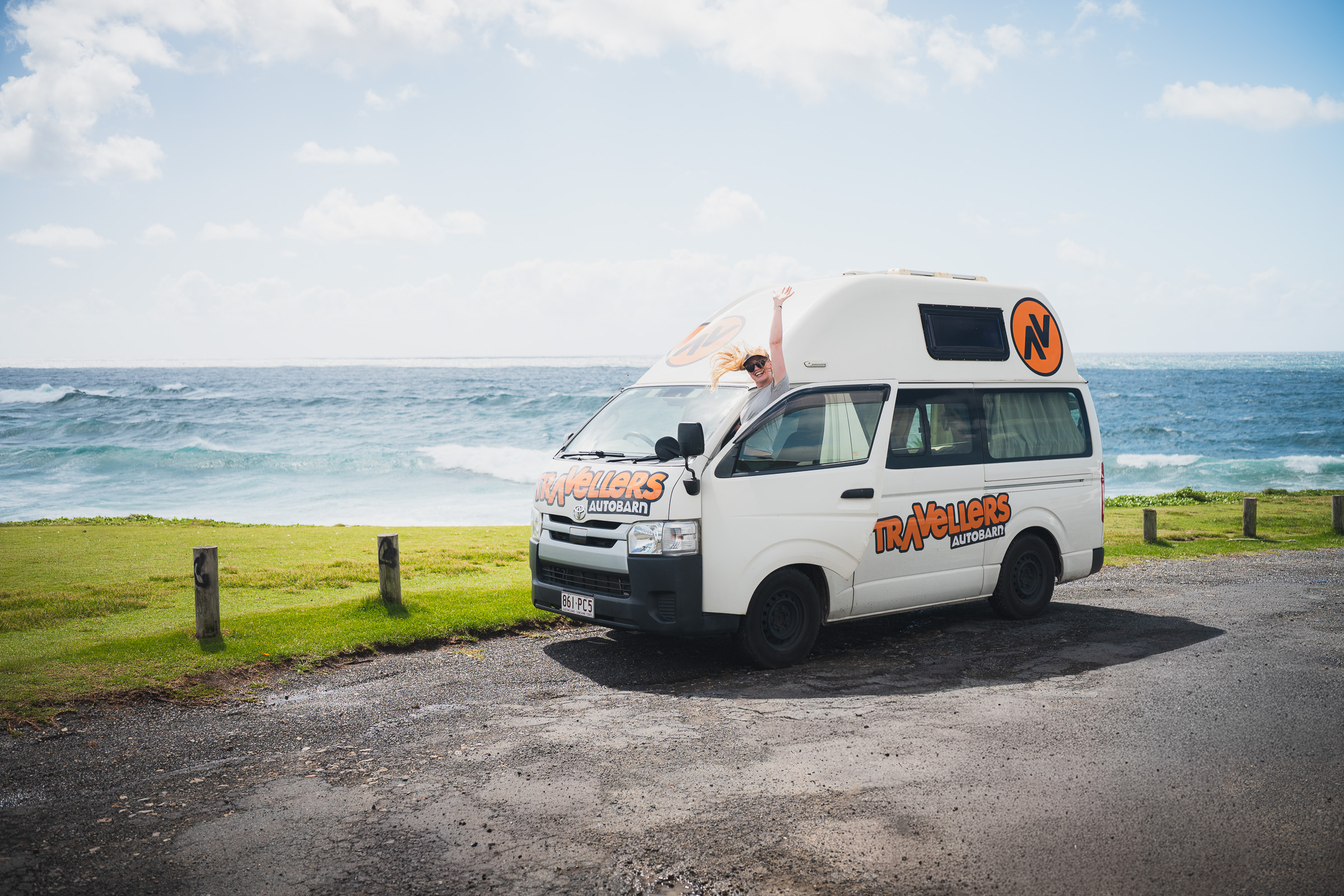 White Travellers Autobarn camper parked on a grassy coastal headland