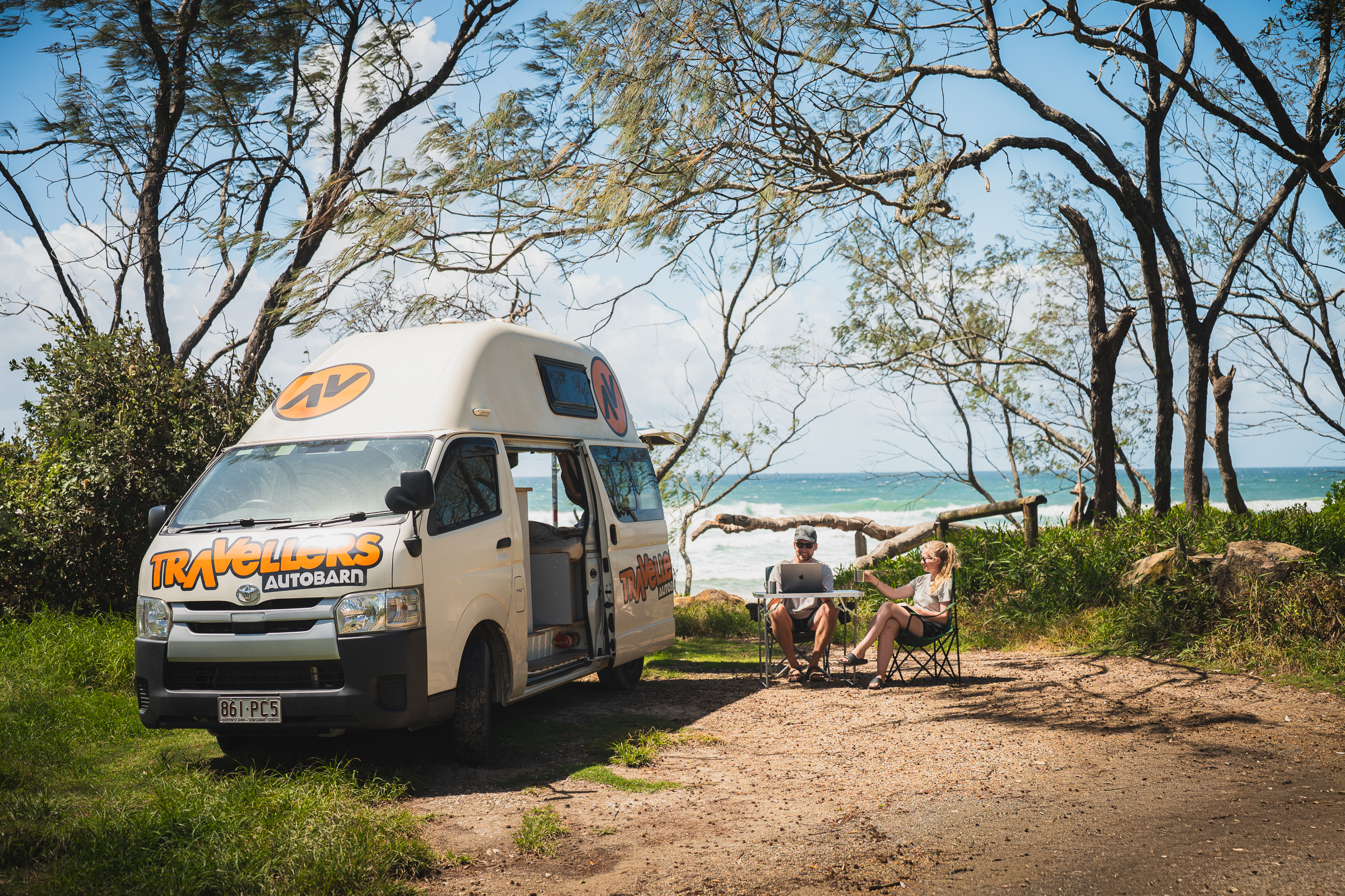 Travellers Autobarn camper at a shaded campsite beside the beach