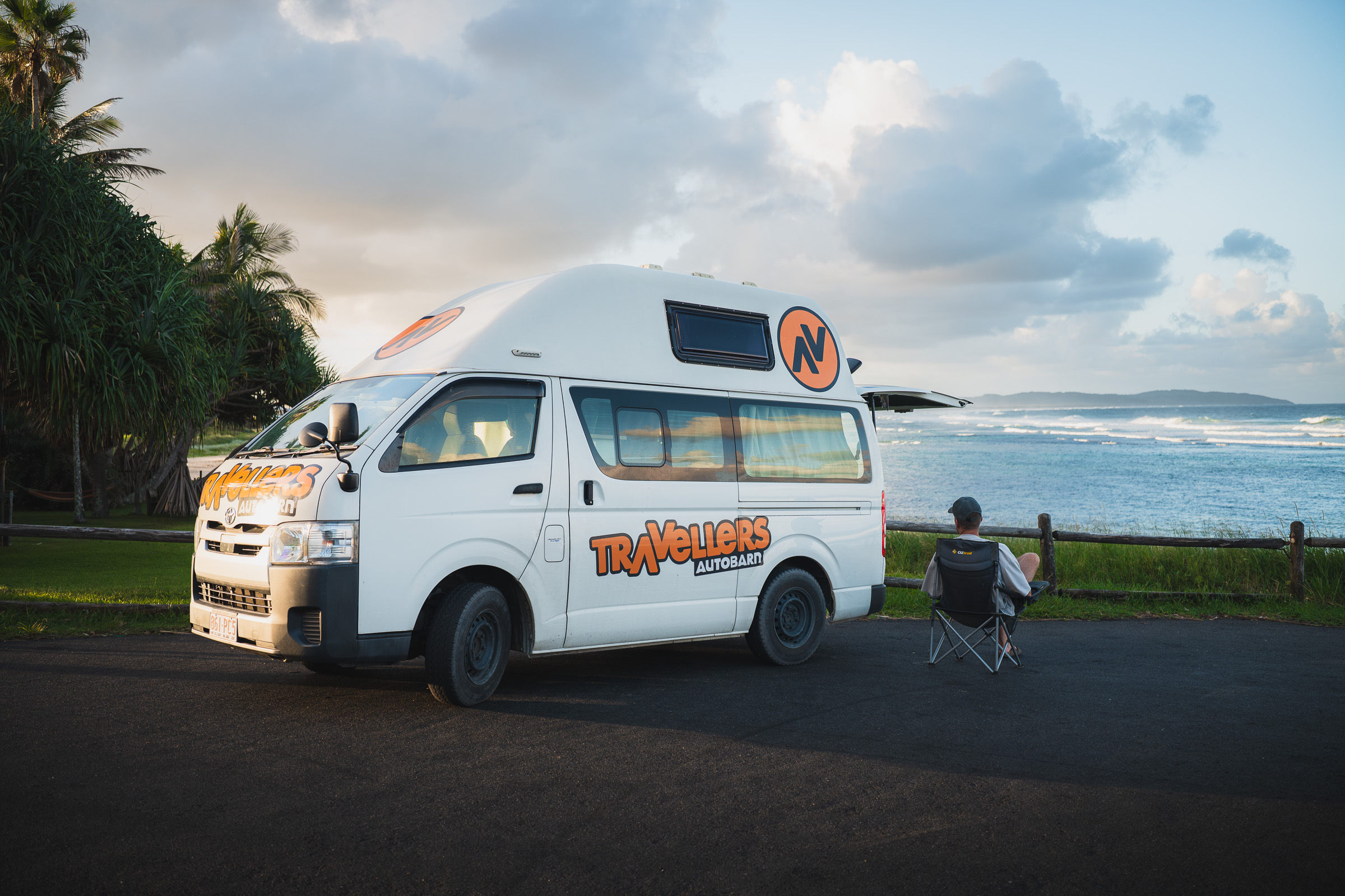 Camper van and folding chair overlooking waves along the Australian coast
