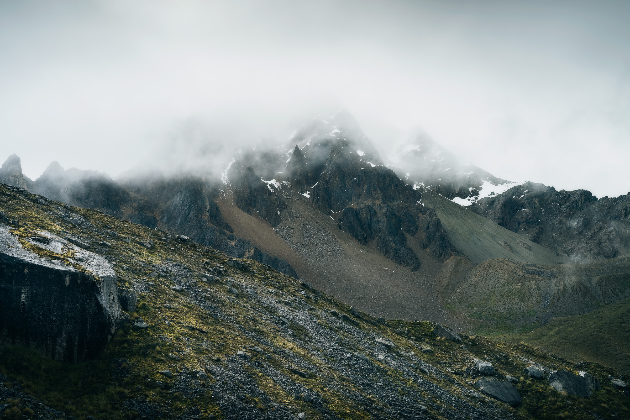 Dark rocky Salkantay ridge partly hidden by thick clouds