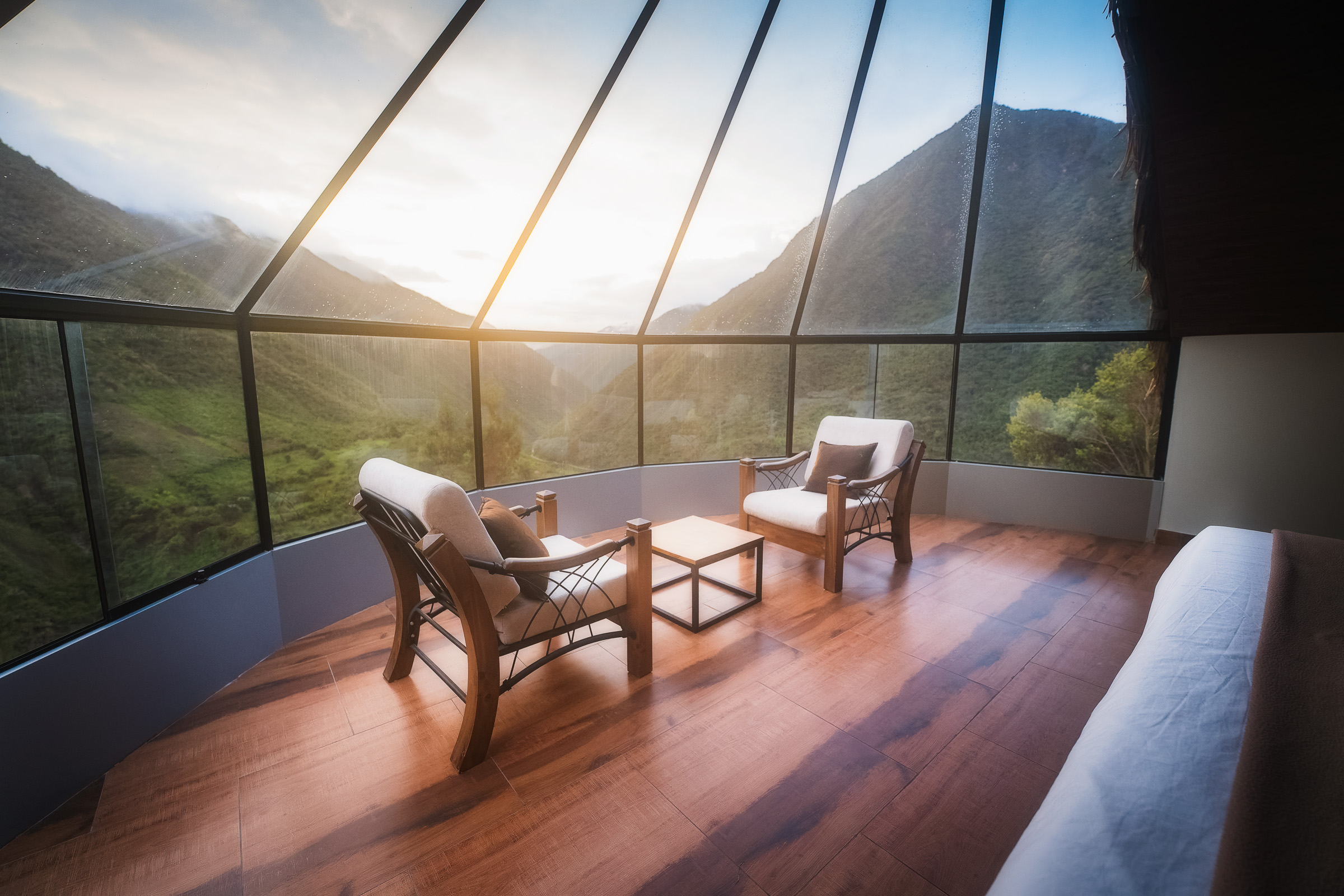 Mountain lodge bedroom glowing in the early light through panoramic windows