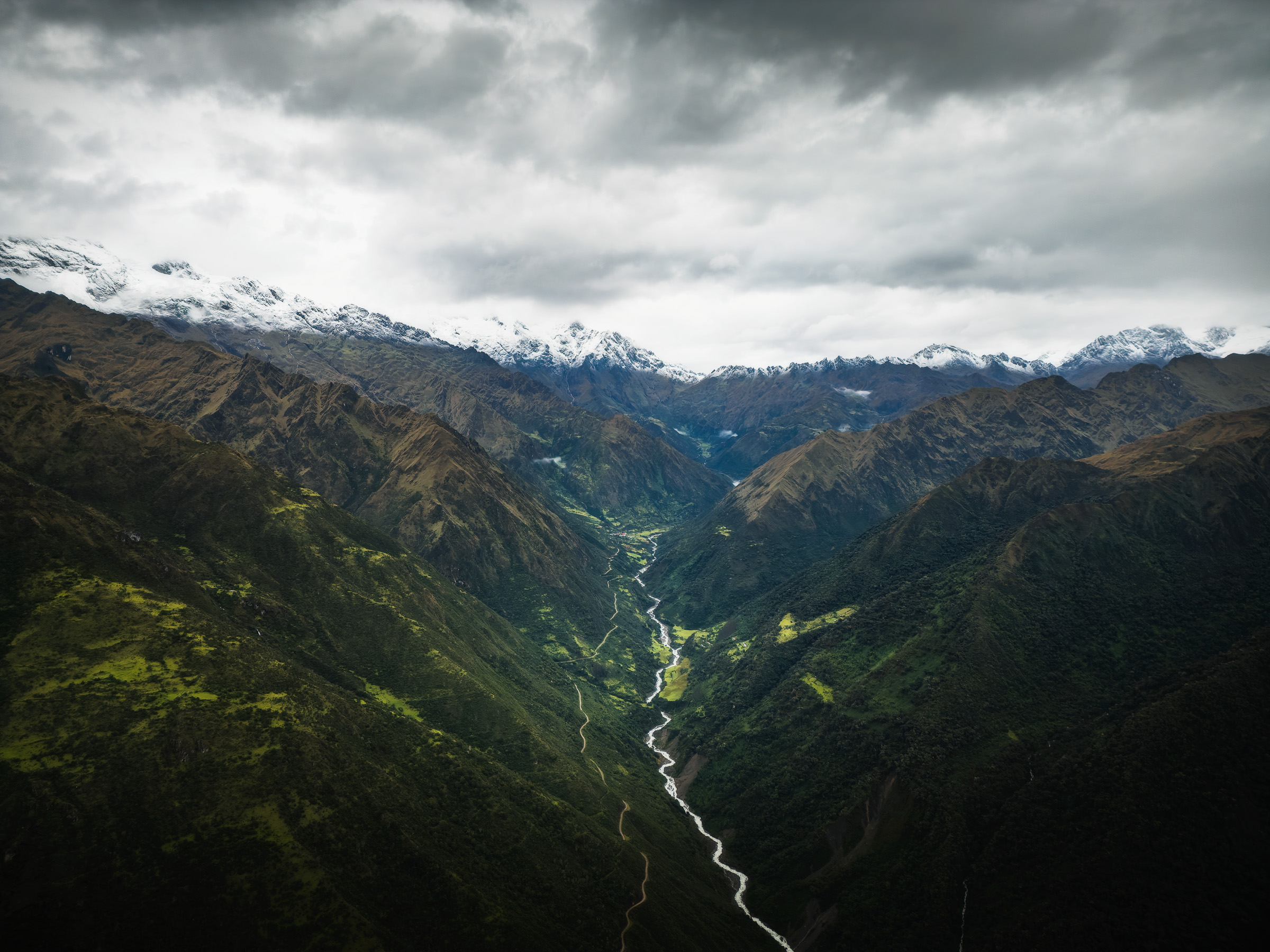 River winding through a deep Andean valley beneath snowy peaks