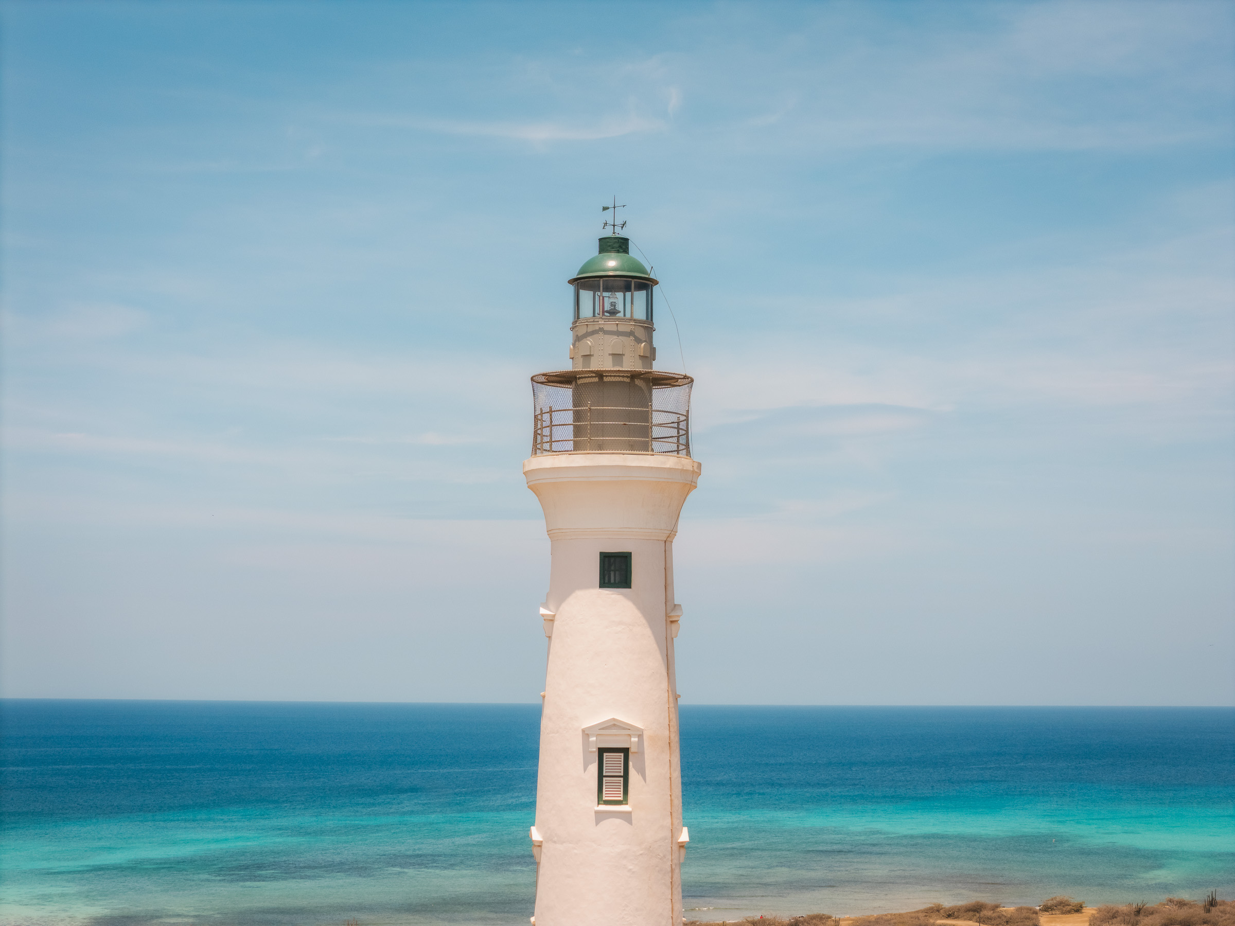 California Lighthouse overlooking the blue Caribbean Sea in Aruba