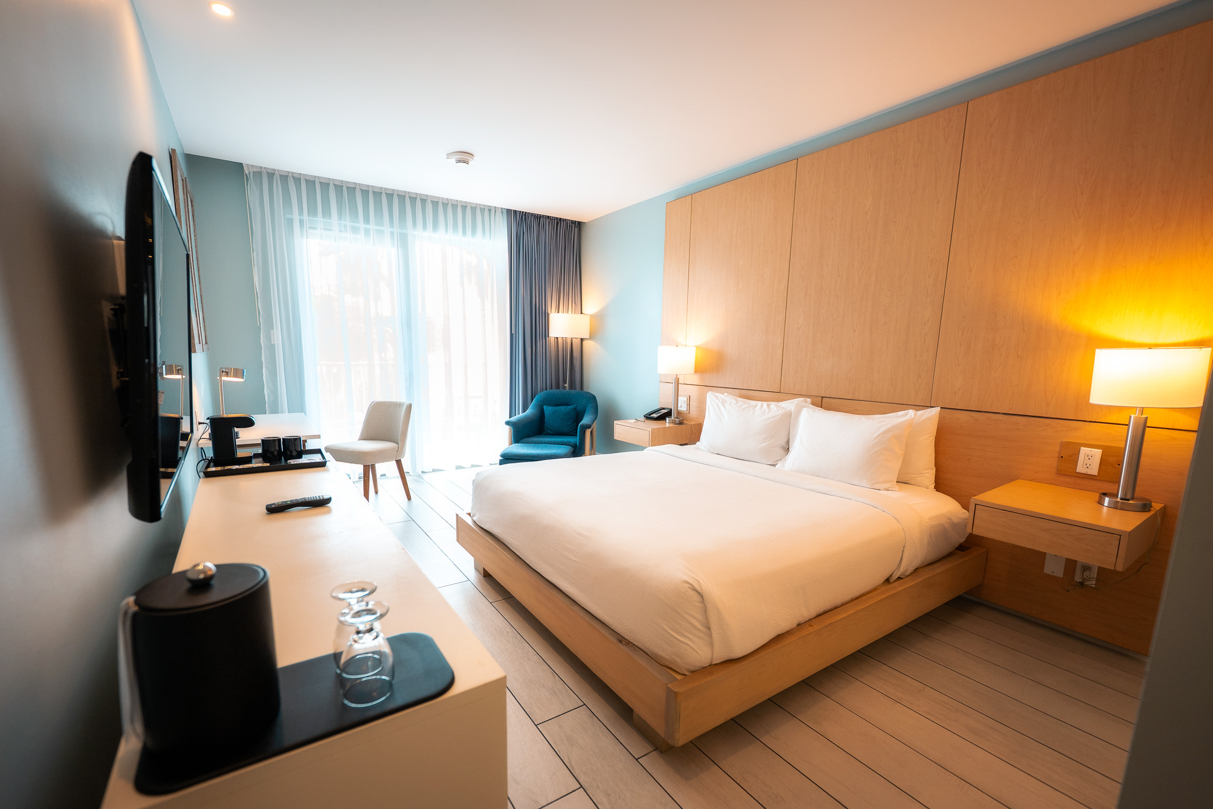 Courtyard Aruba guest room illuminated by a warm bedside lamp
