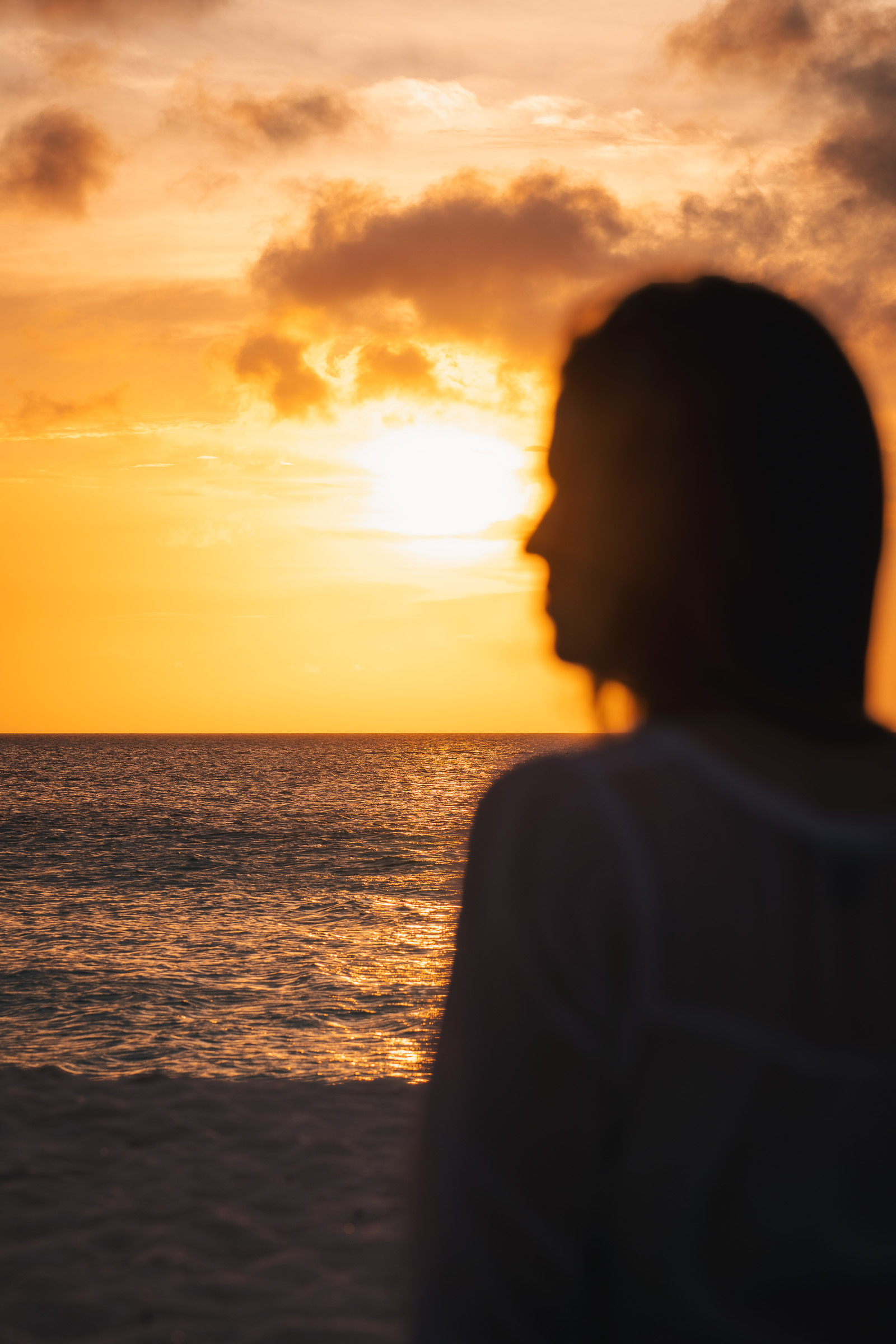 Silhouette of a woman watching the sunset over the Caribbean Sea