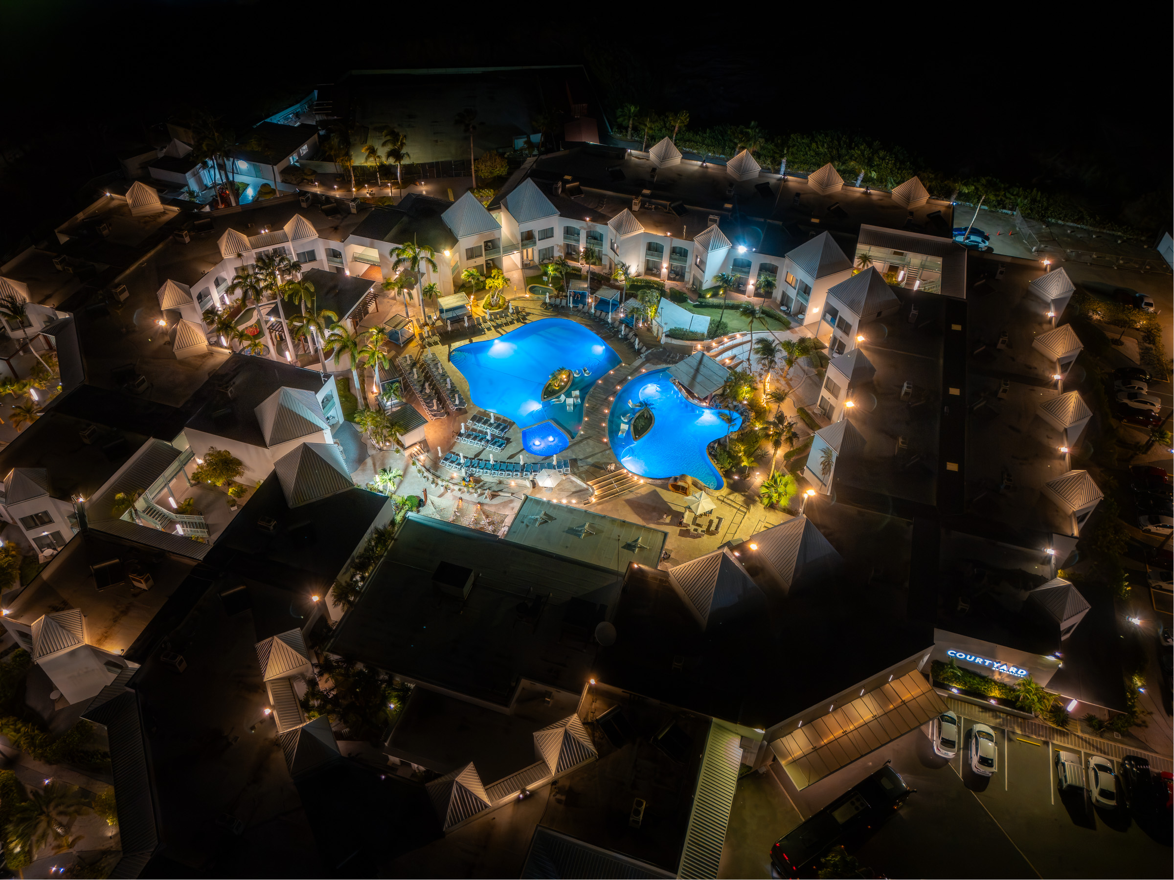 Aerial night view of the pools and buildings at Courtyard Aruba