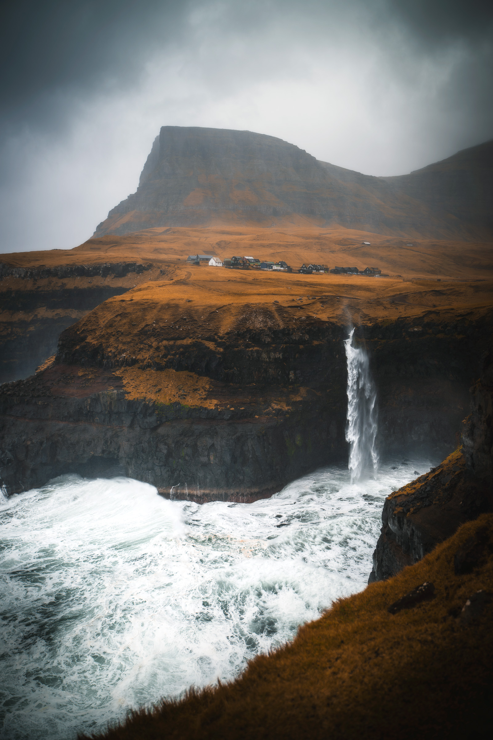 Der Múlafossur-Wasserfall unter einem nebelverhangenen Berg