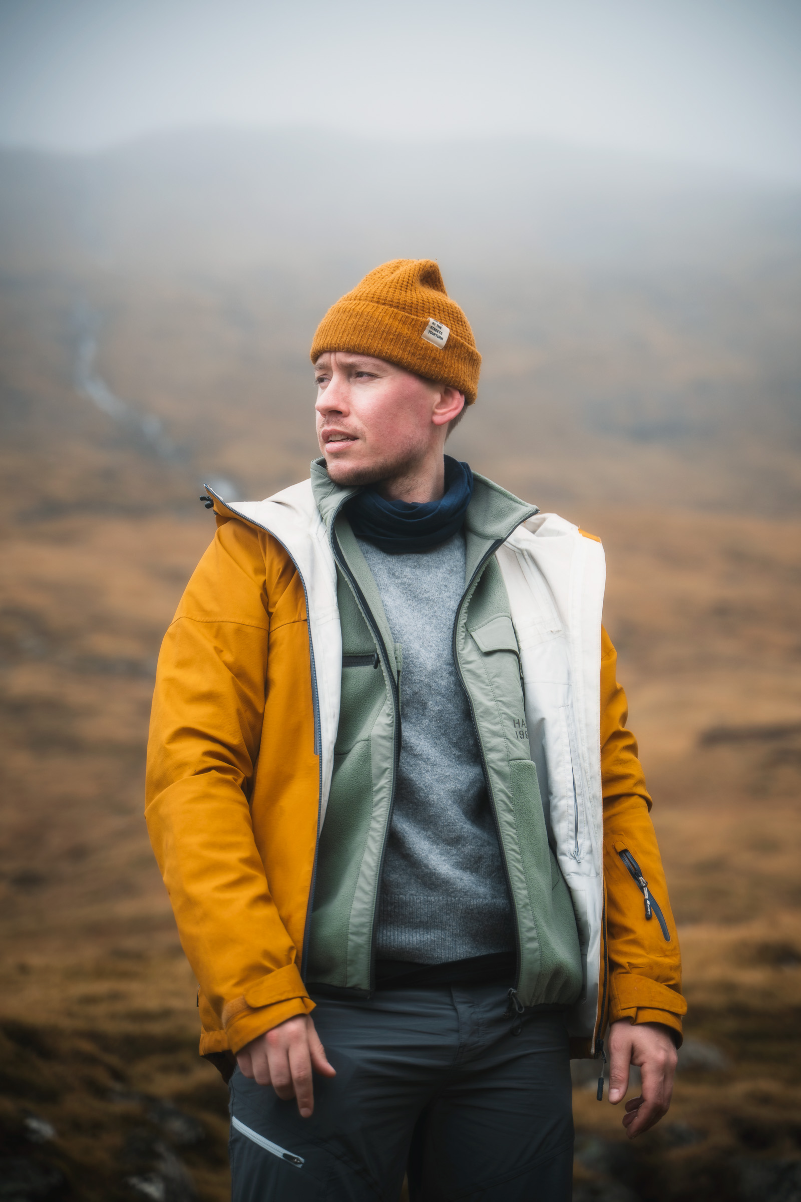 Porträt eines Reisenden in gelber Jacke und orangefarbener Mütze