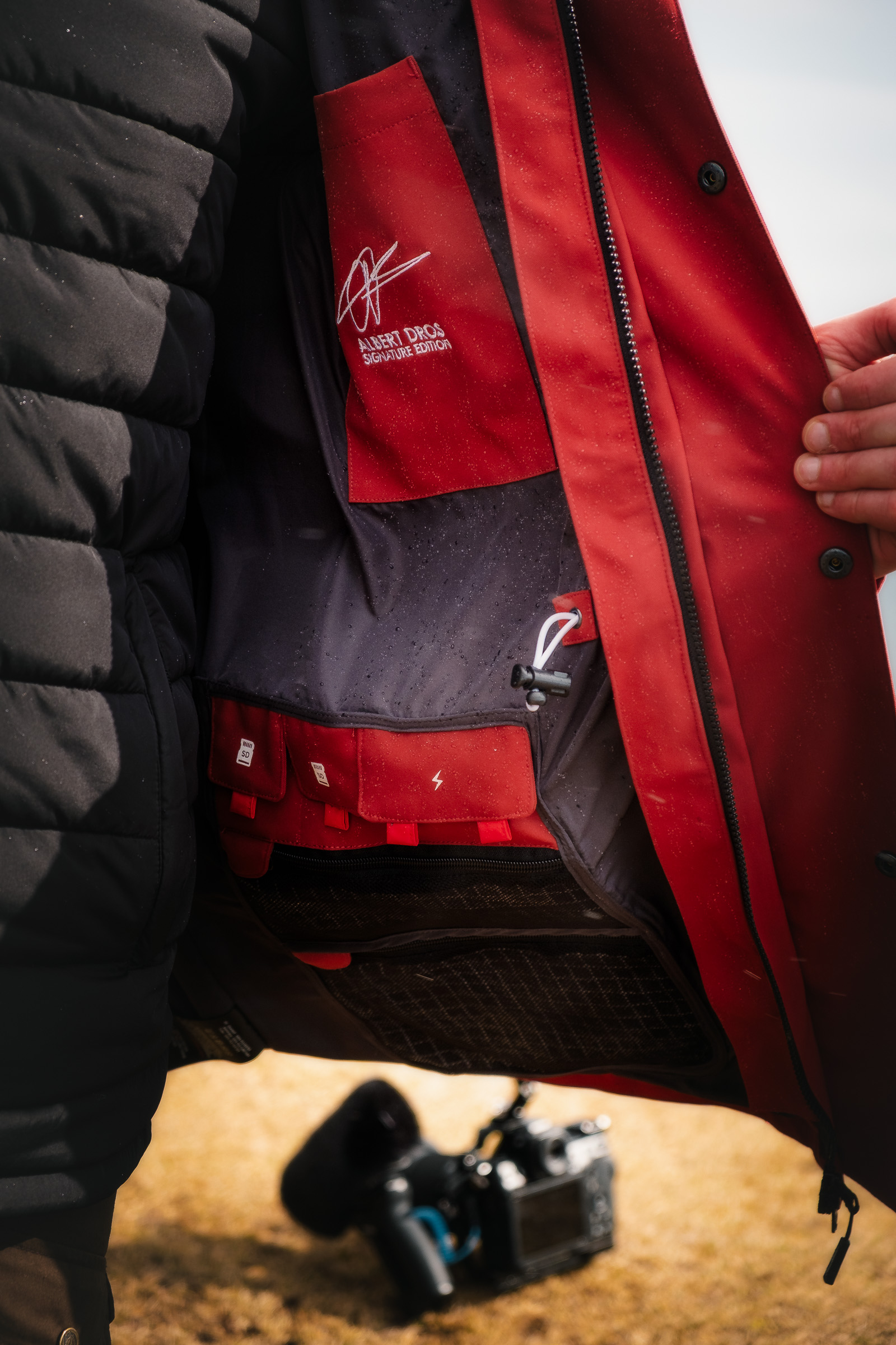 Nahaufnahme der Taschen und Details einer roten Regenjacke
