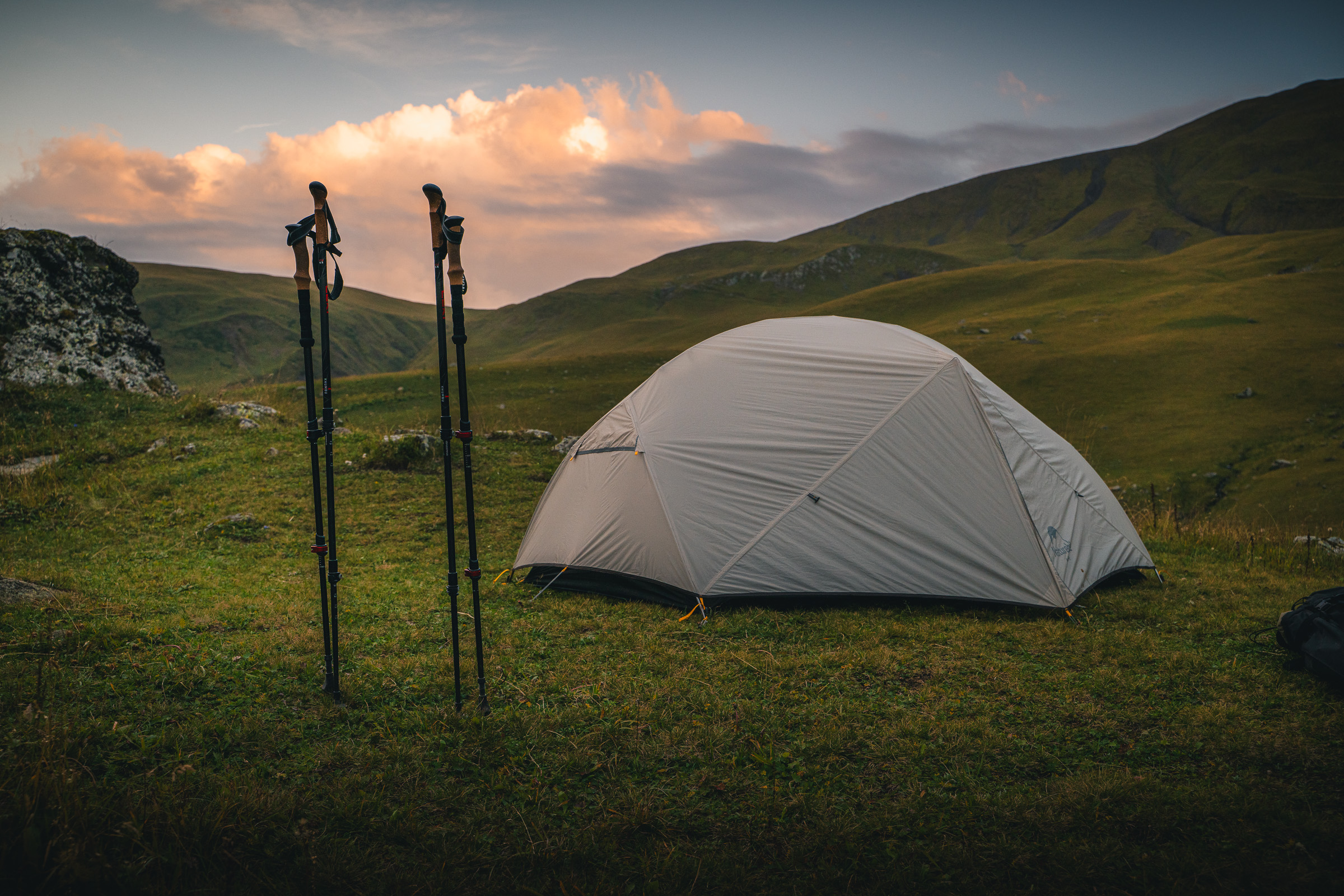 Zelt und Trekkingstöcke an einem hoch gelegenen Bergcamp