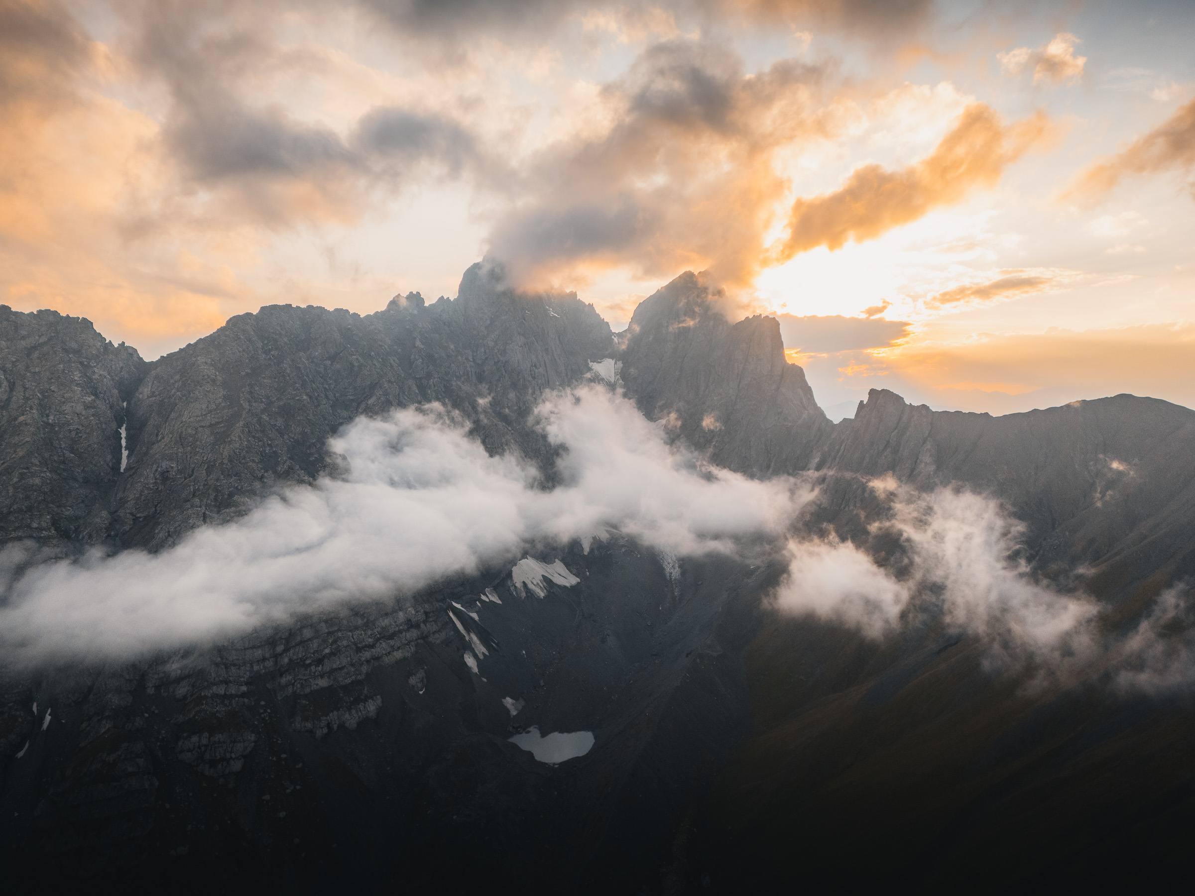 Wolken ziehen durch einen dunklen zerklüfteten Gebirgskamm