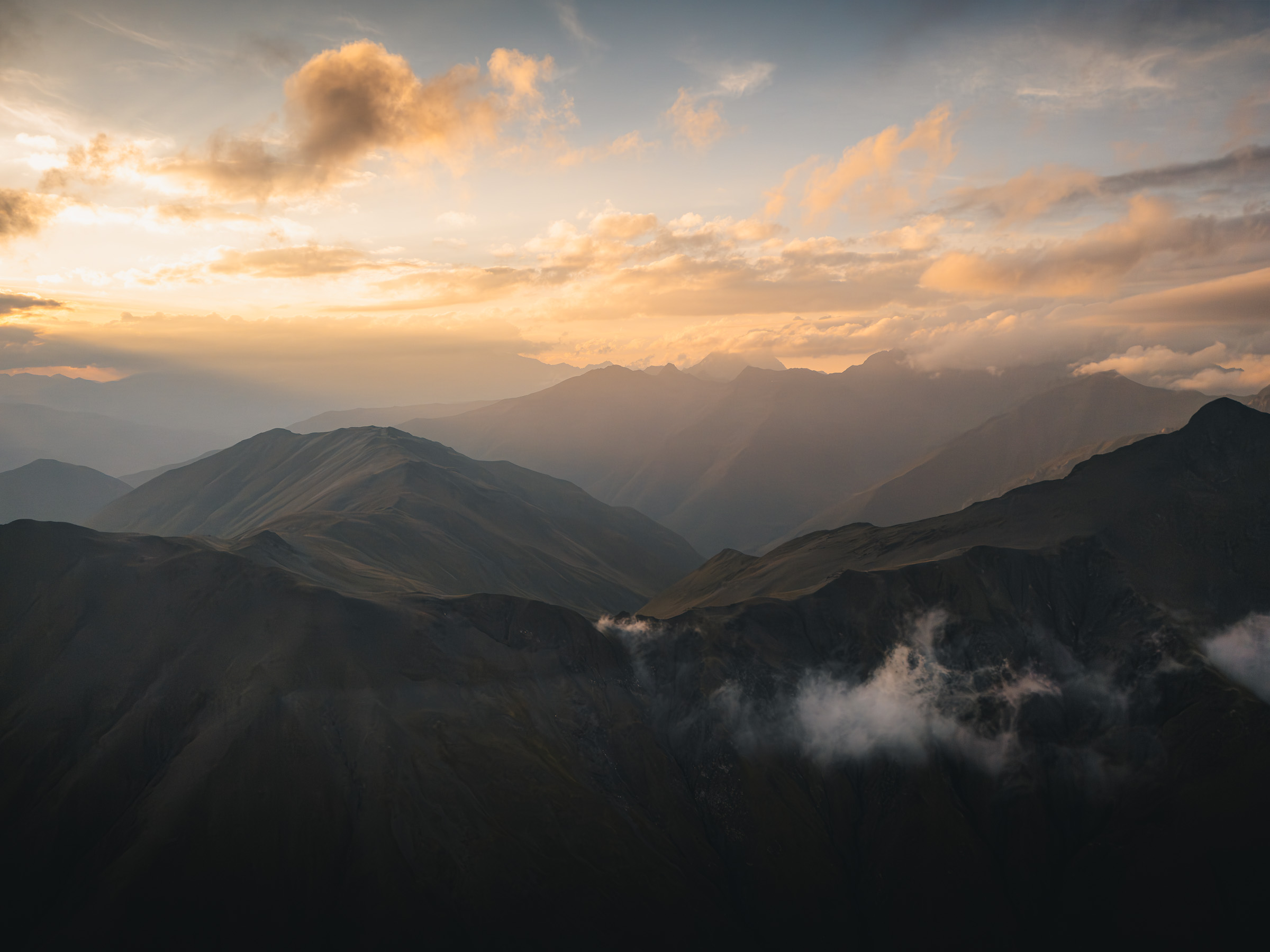 Warmer Sonnenuntergang über gestaffelten Bergrücken in Georgien