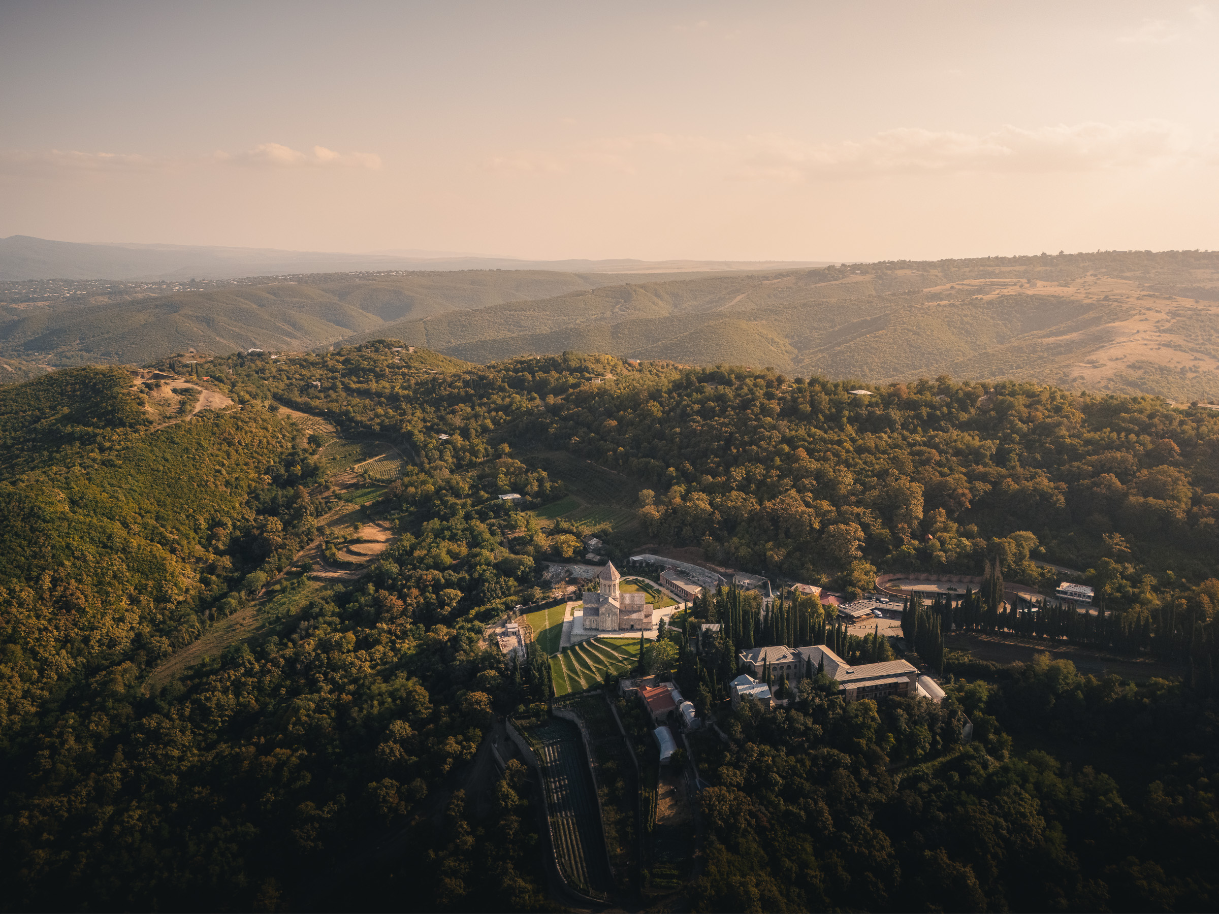 Luftaufnahme der hügeligen georgischen Landschaft in warmem Abendlicht
