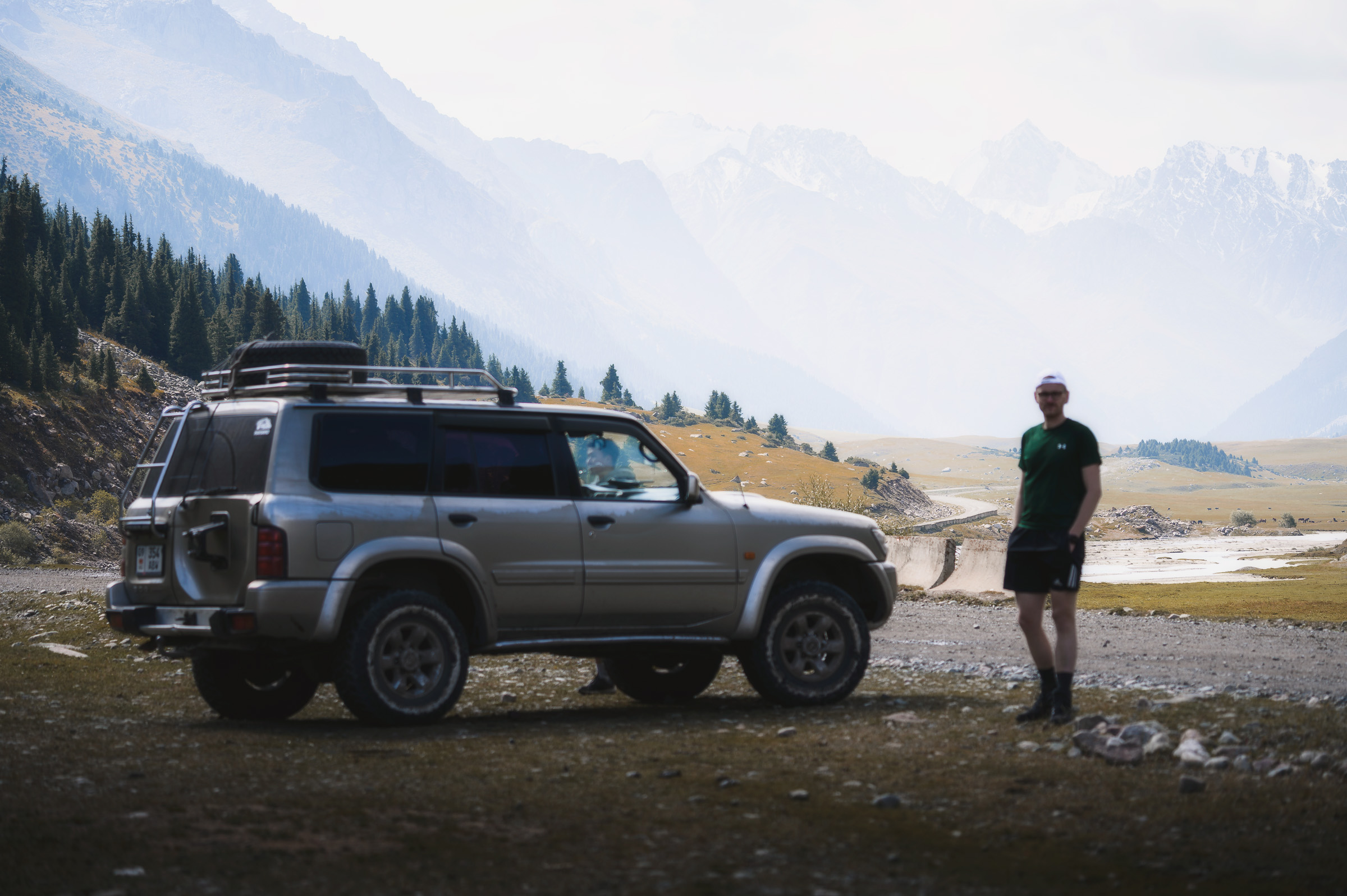 Traveler and off-road vehicle in a remote mountain valley
