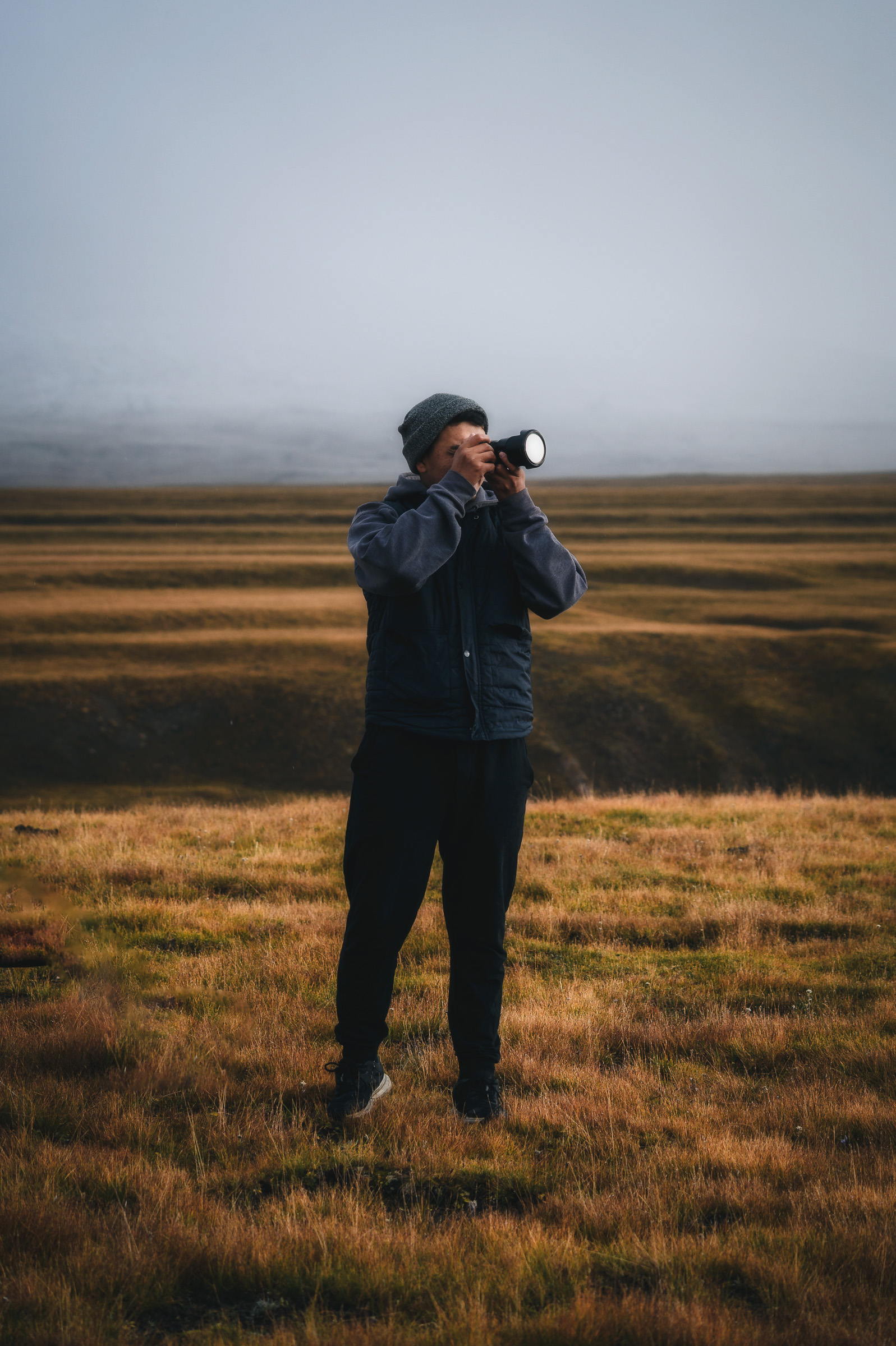 Photographer standing alone on the open Kyrgyz steppe