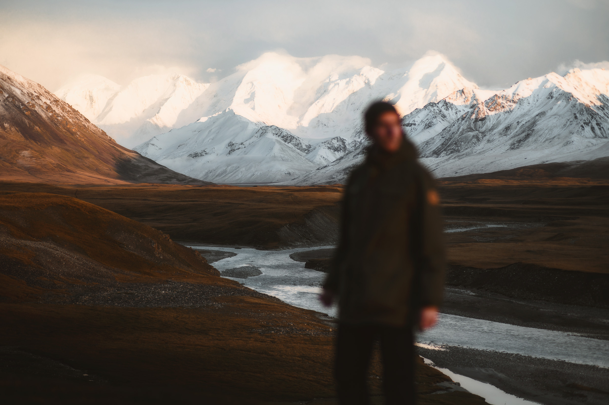 Traveler standing in a valley framed by white peaks