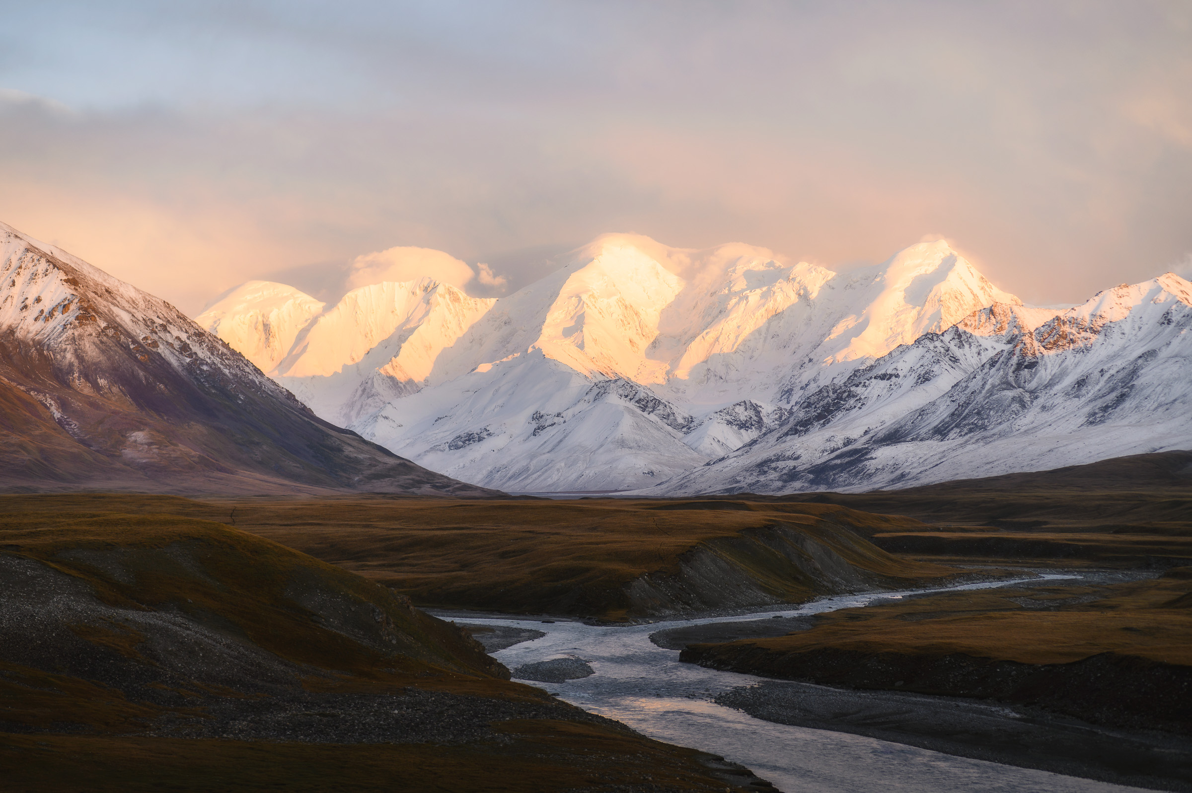 Snow-covered mountain range glowing in early sunlight