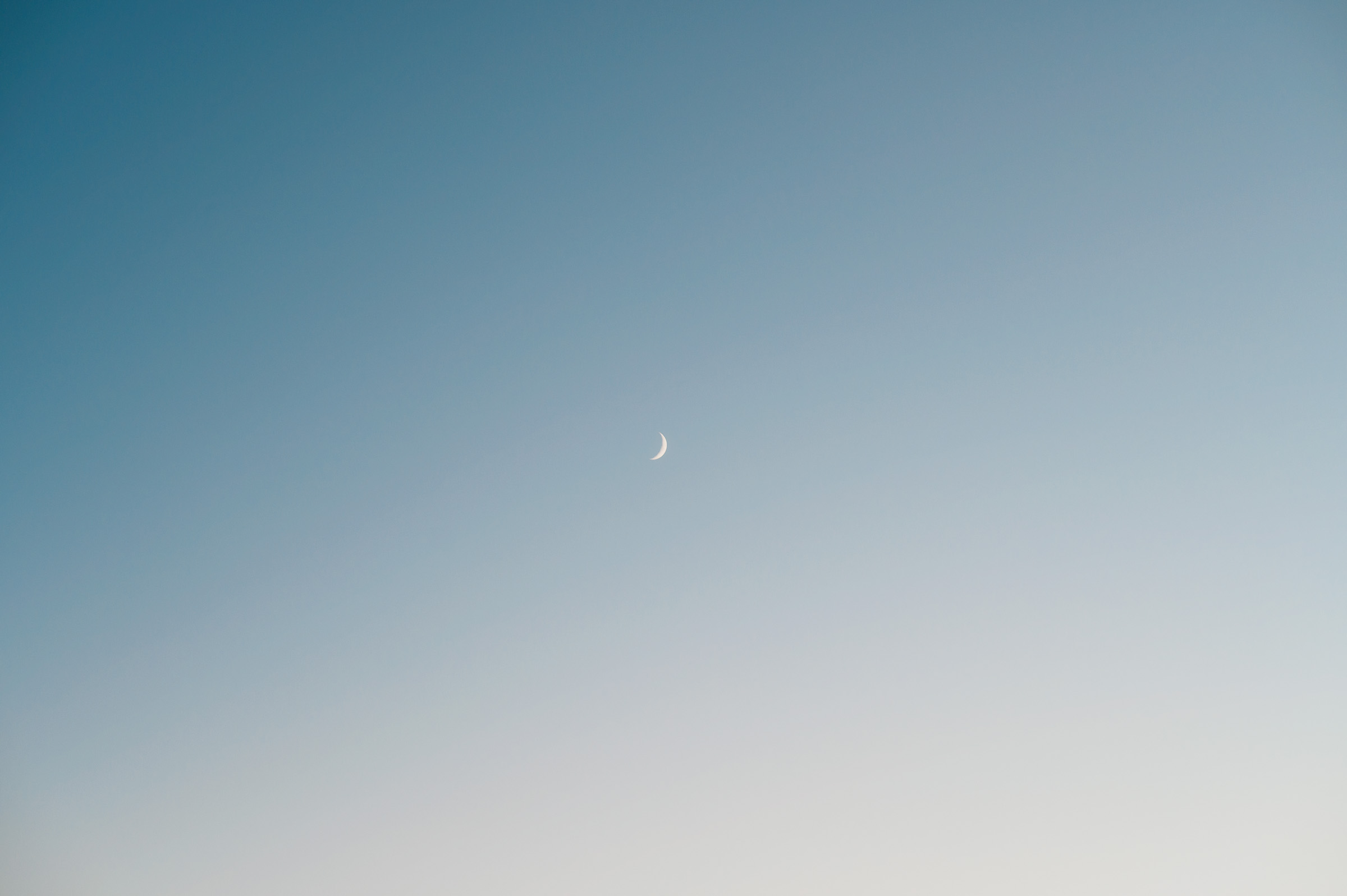 Slender crescent moon in a clear twilight sky