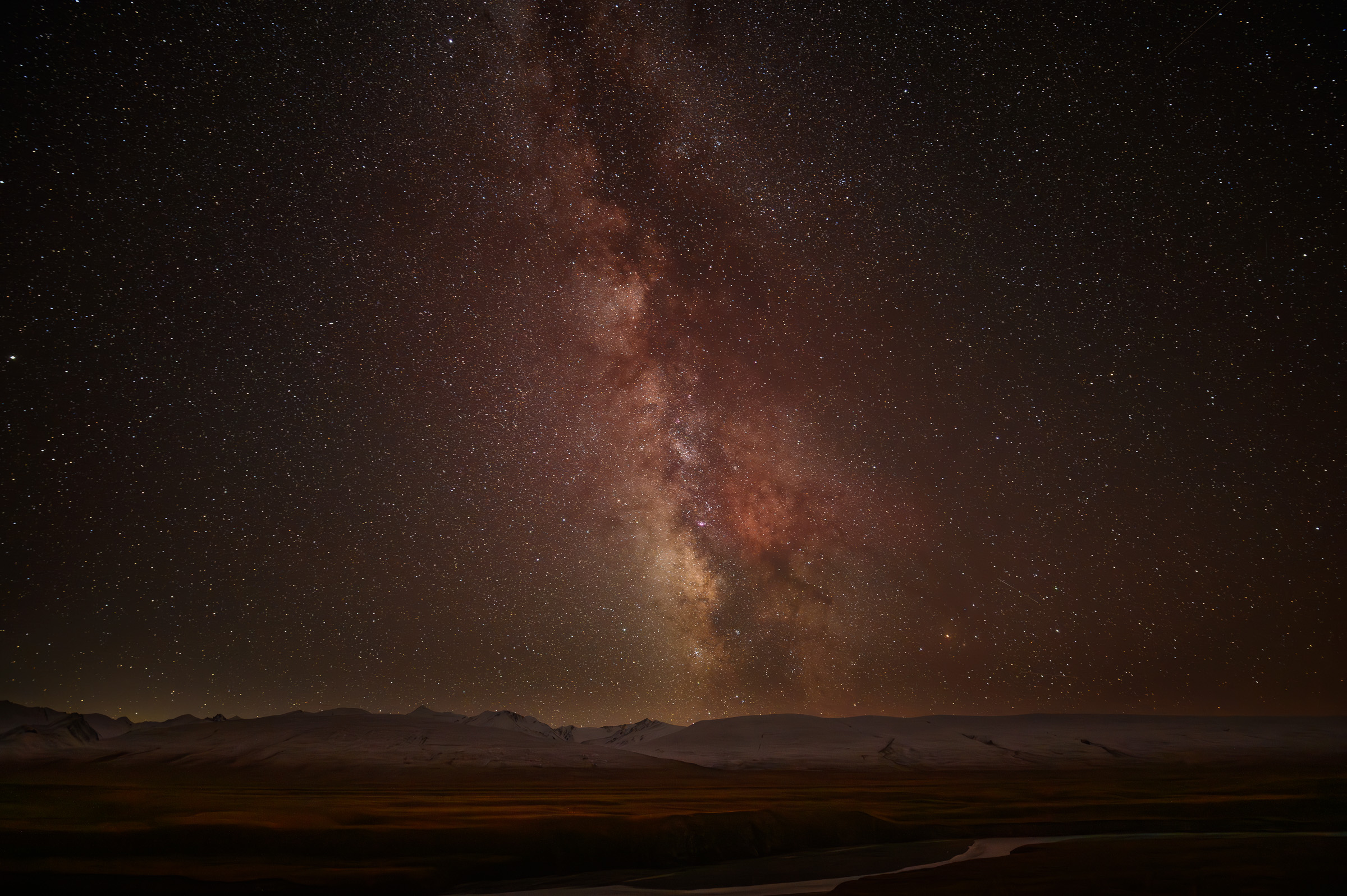 Milky Way arching above dark Kyrgyz mountains