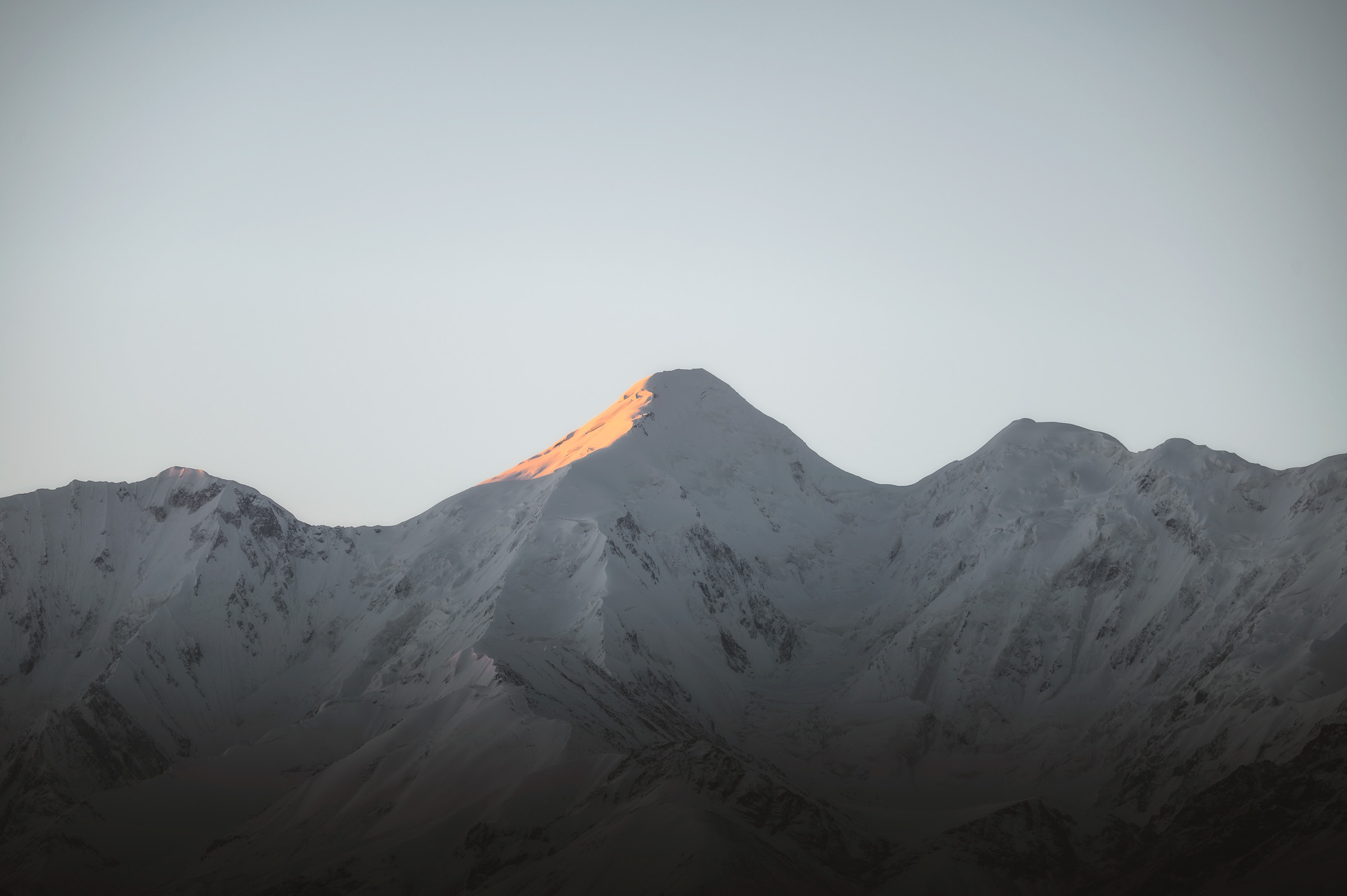 First sunlight touching the summit of a snowy mountain