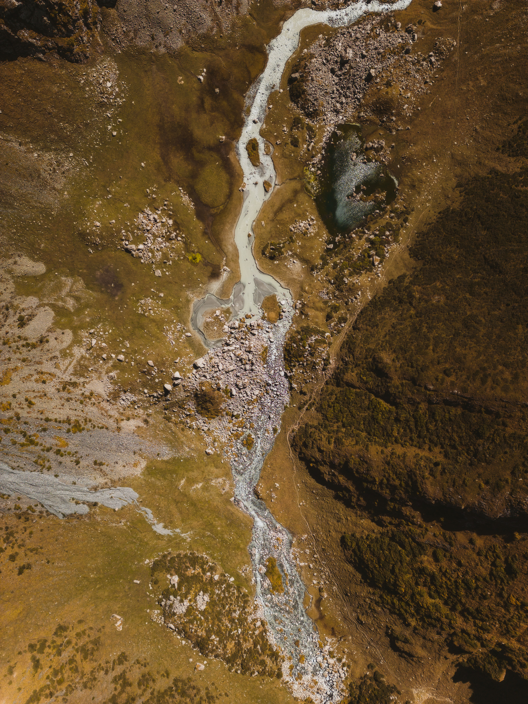 Top-down view of a winding stream through rocky terrain