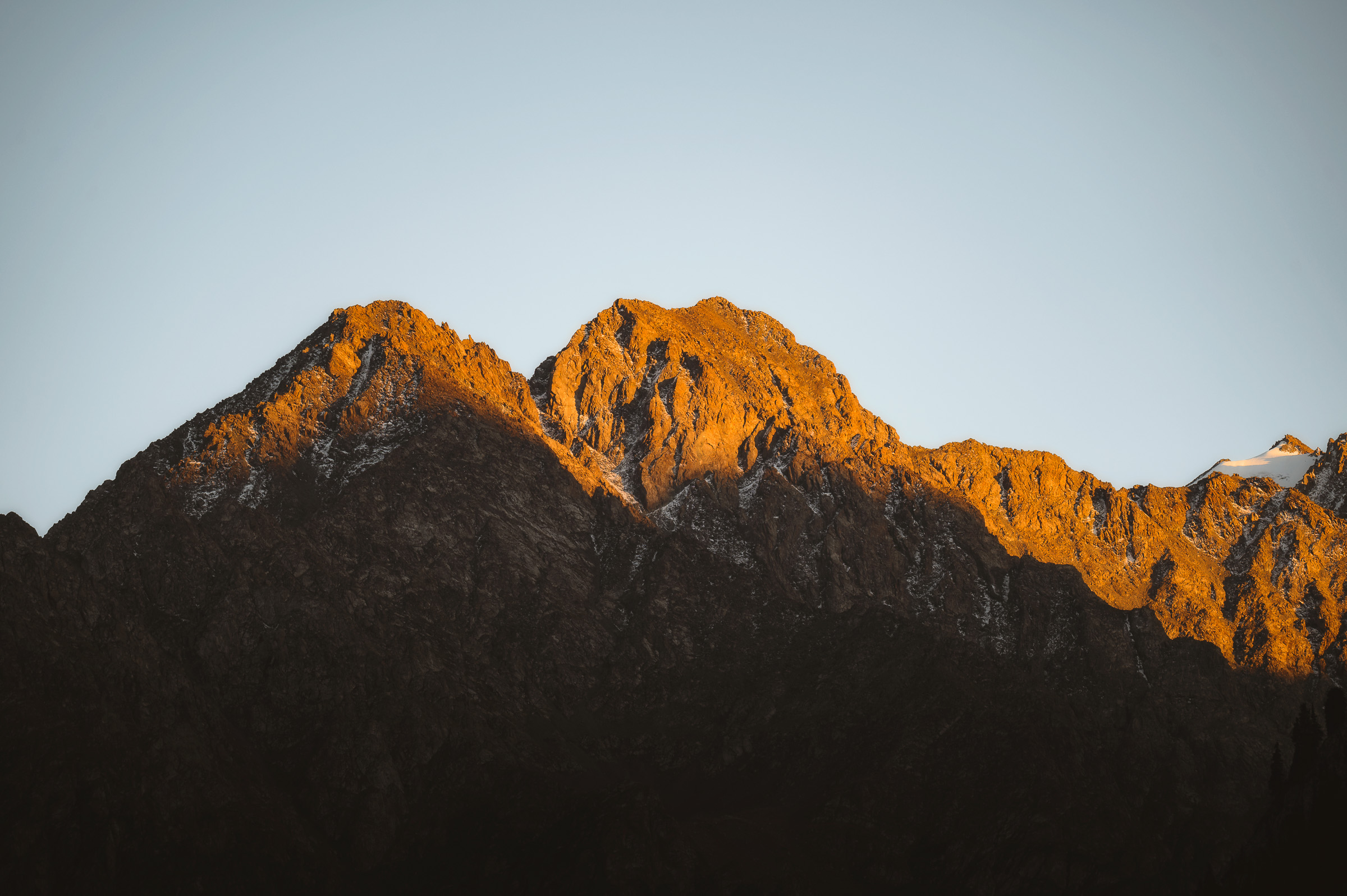 Jagged mountain peaks glowing orange in the first light