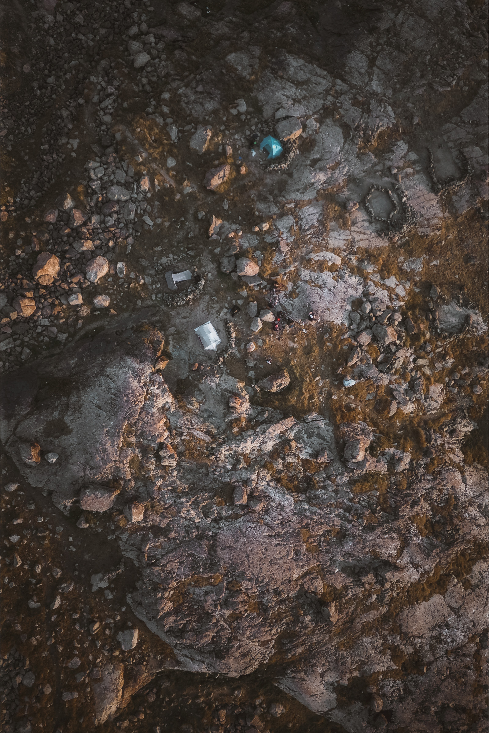 Top-down view of a stream crossing rust-colored rock