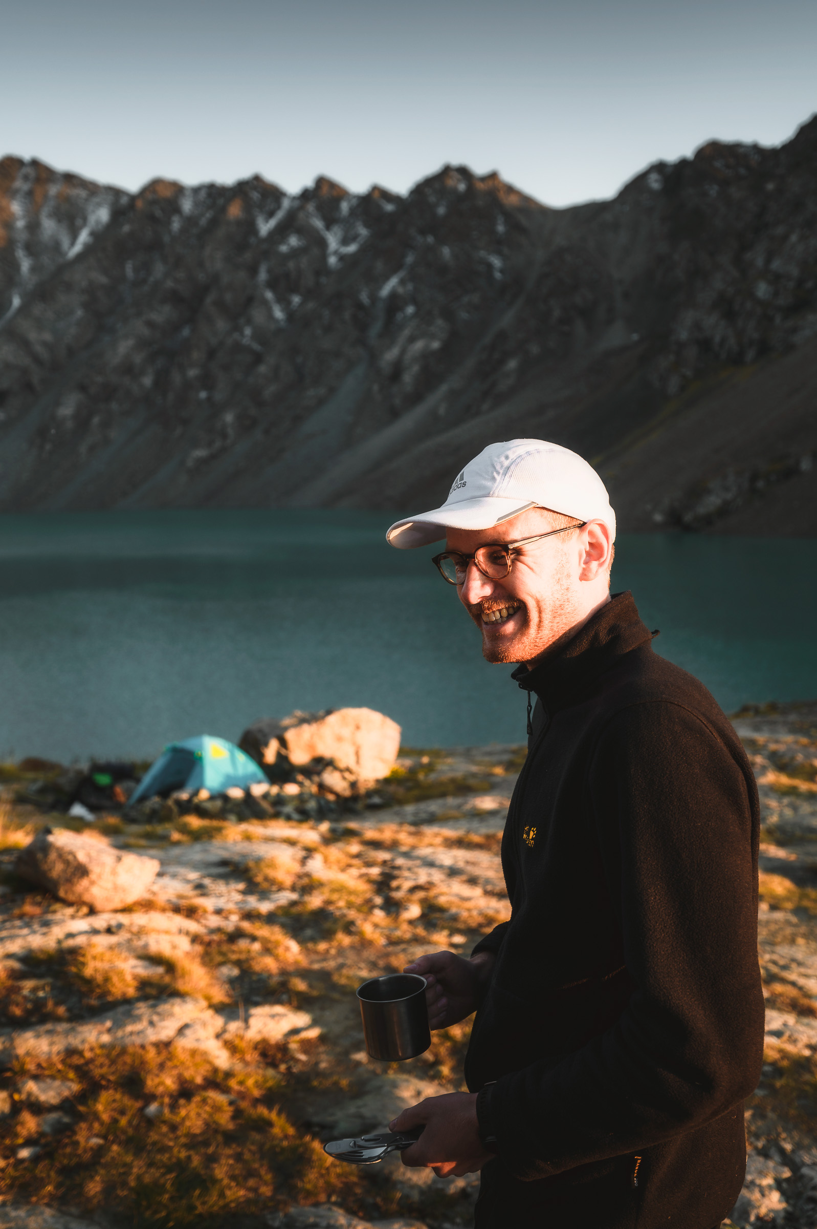 Smiling traveler beside a turquoise mountain lake