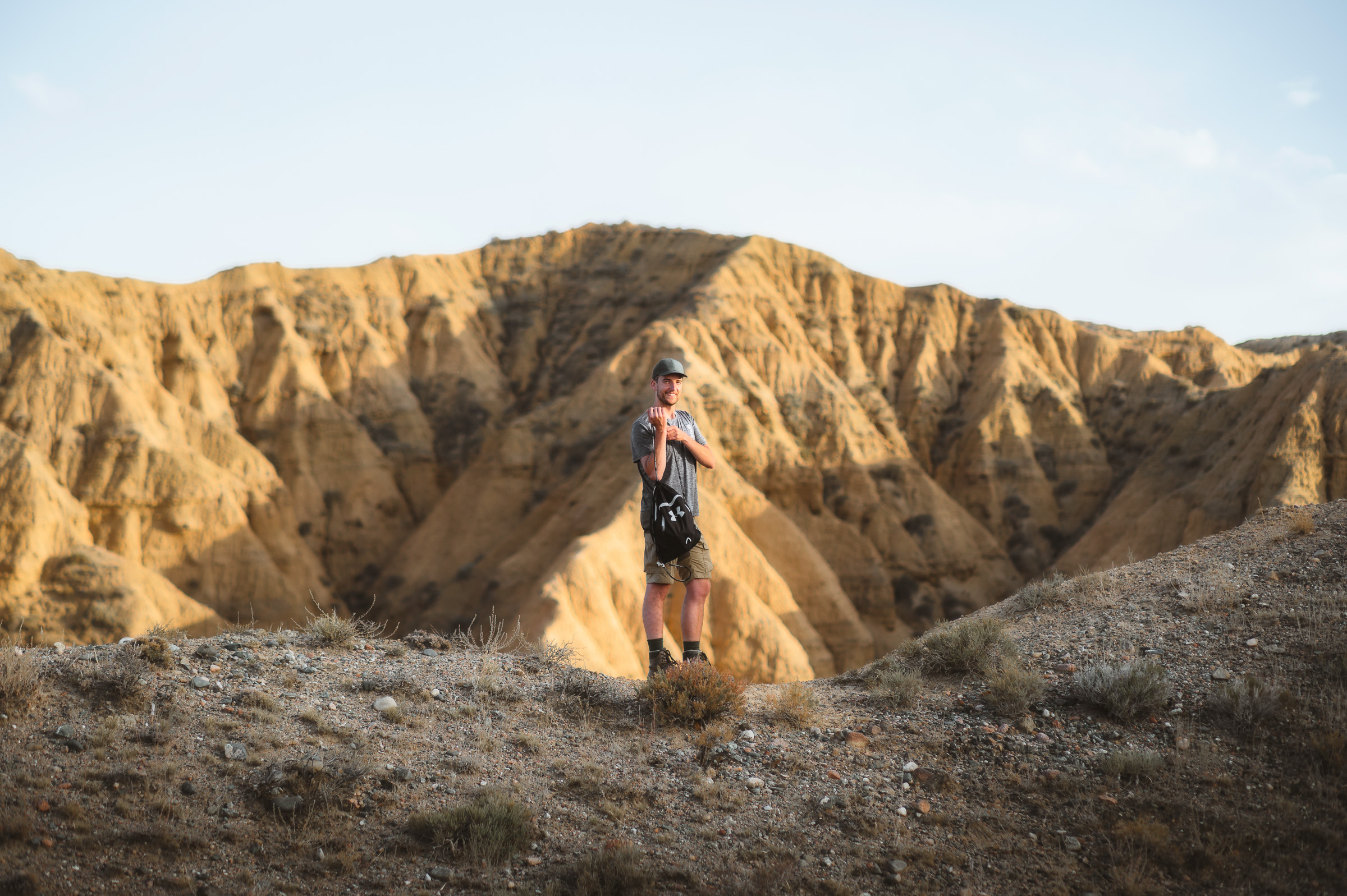 Traveler exploring sunlit formations in the badlands