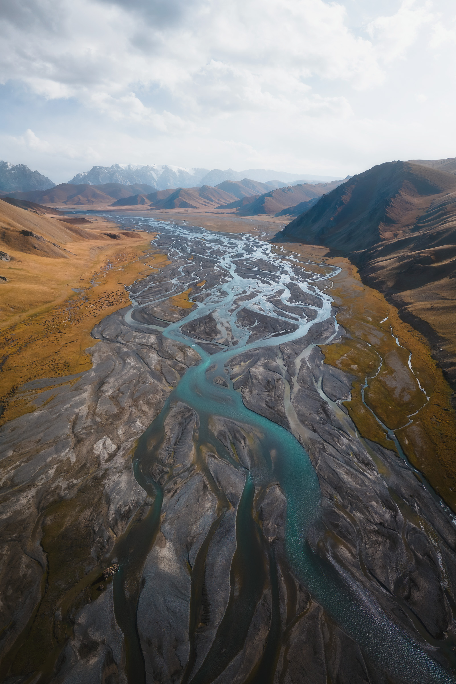 Aerial view of a braided turquoise river in a broad valley