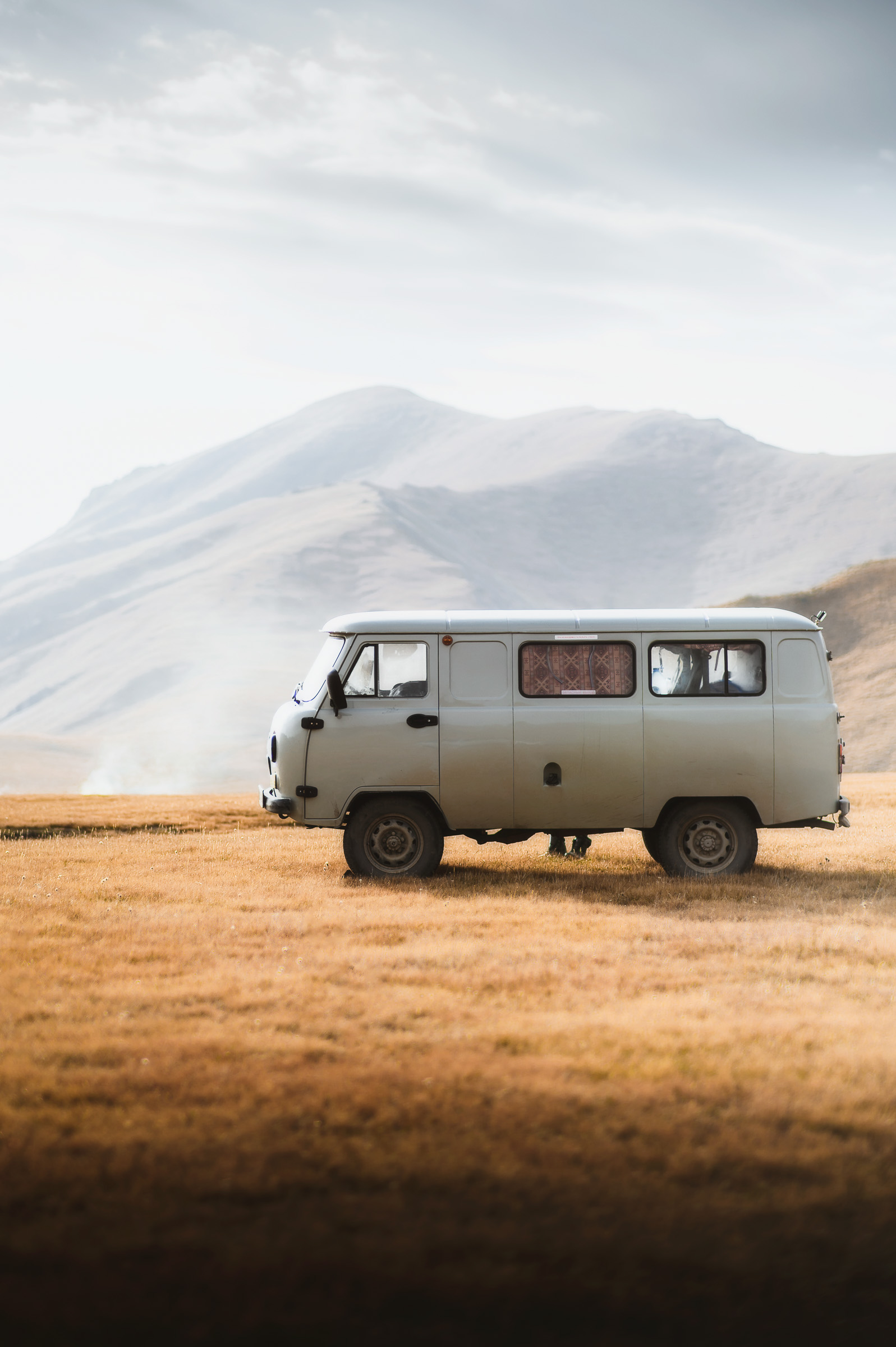 White expedition van parked on a remote highland plain