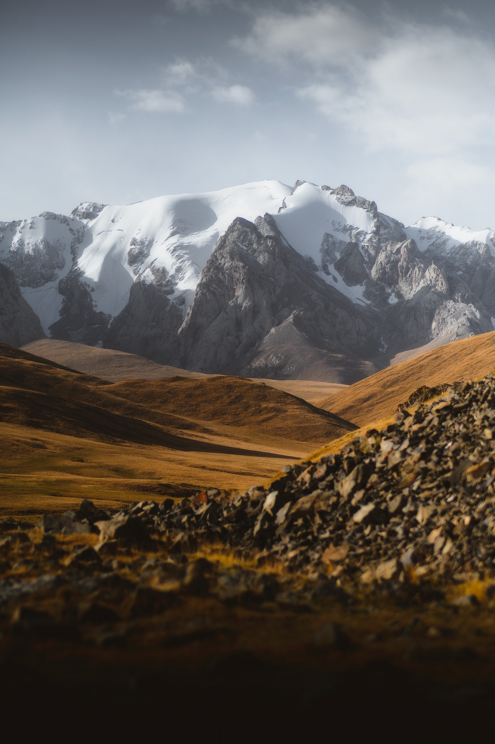 Snow-covered peaks rising beyond a rocky foreground