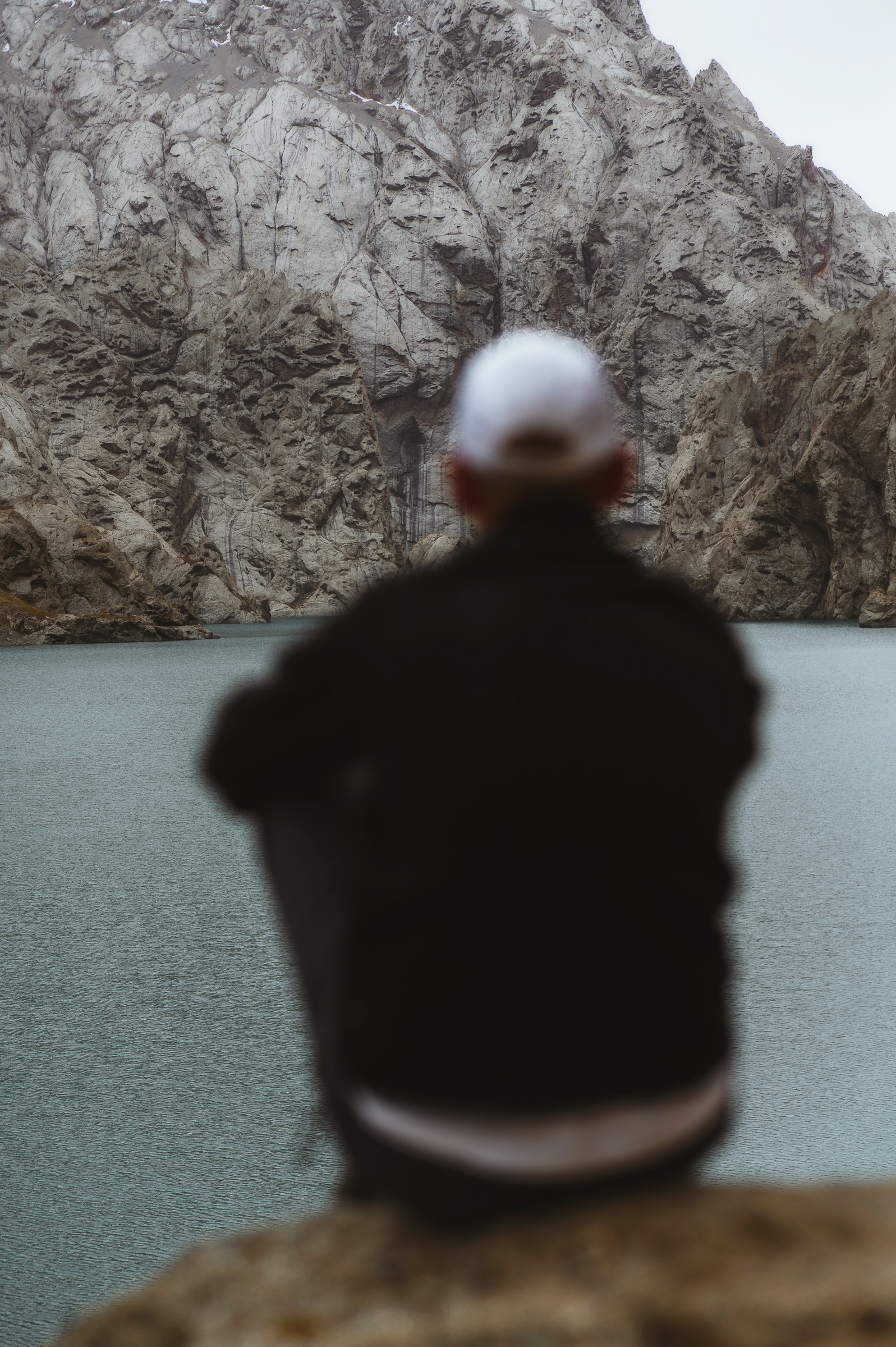 Traveler seated beside a turquoise canyon lake
