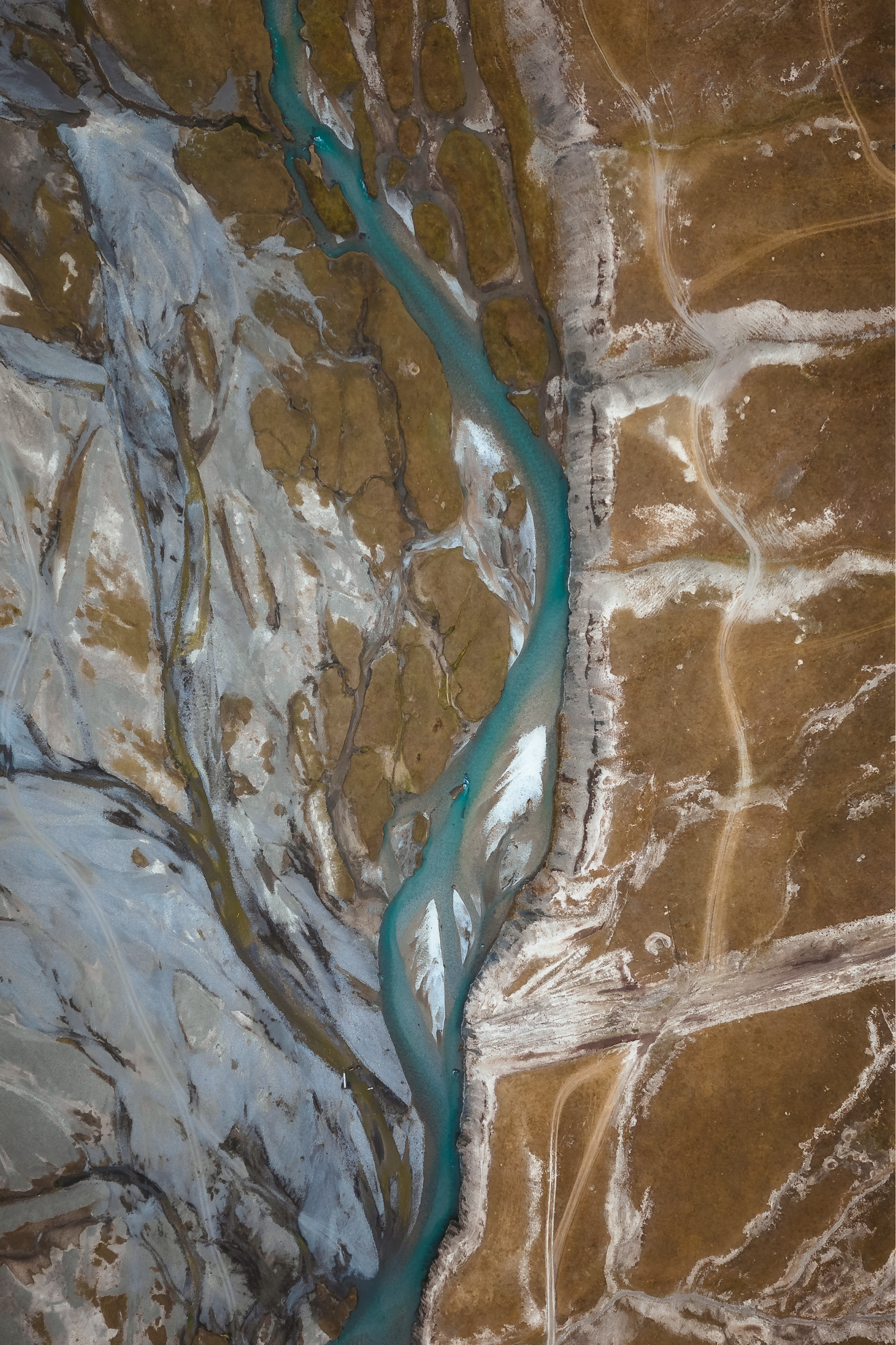Top-down view of a turquoise river through a rocky canyon