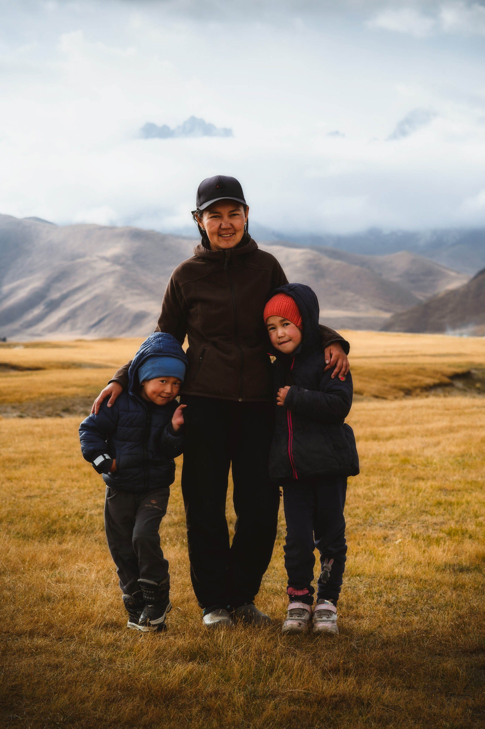 Adult and two children standing together on the open plain