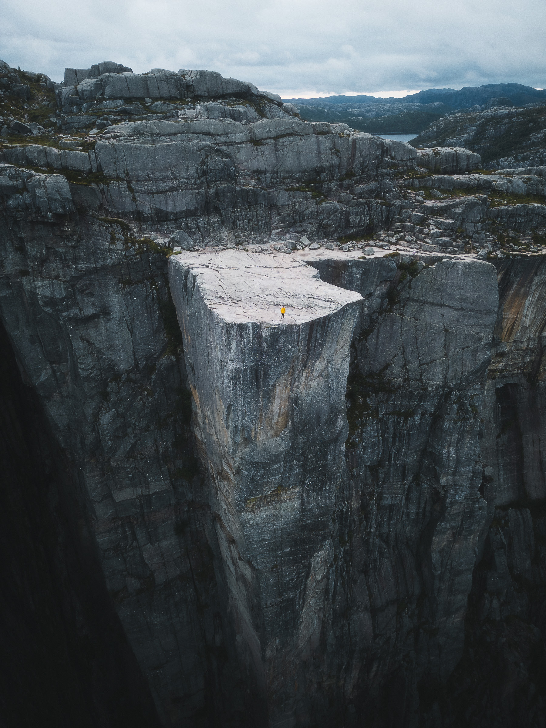 Aerial view of Preikestolen with a hiker near the cliff edge